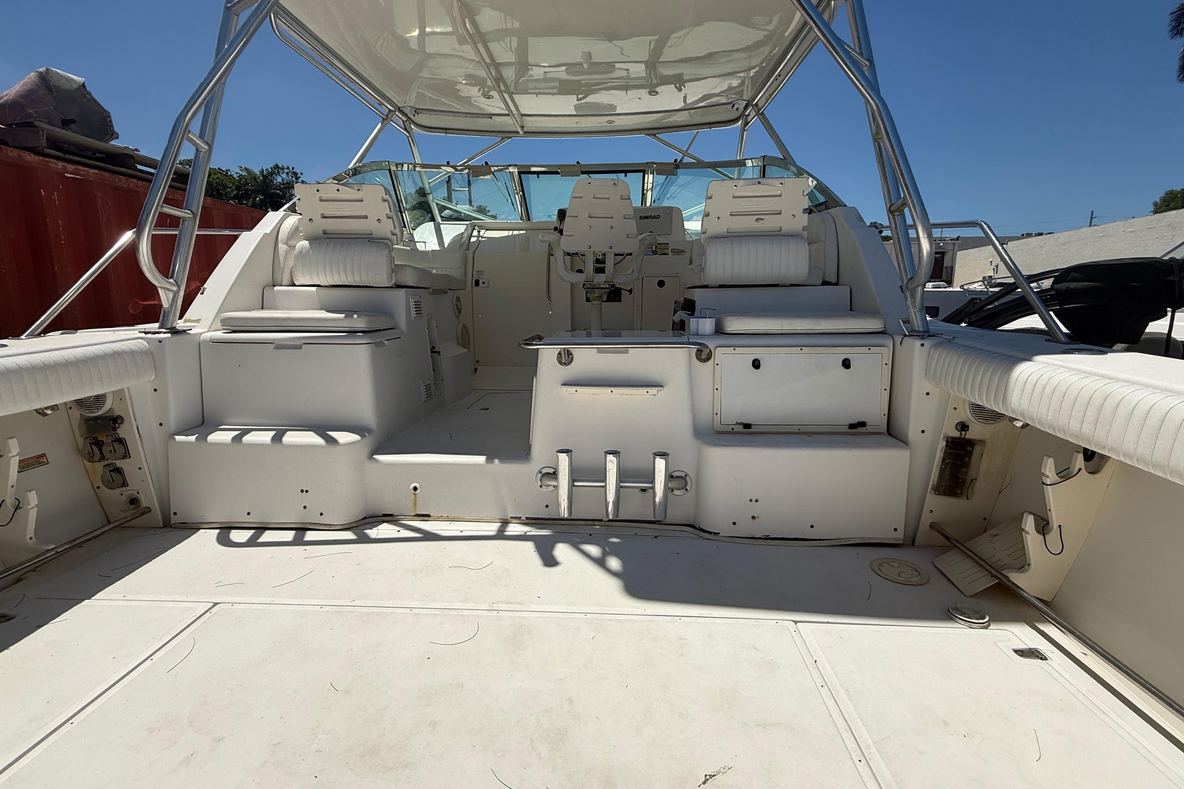 2002 Boston Whaler 350 Defiance boat interior with seating and helm, under clear blue sky.