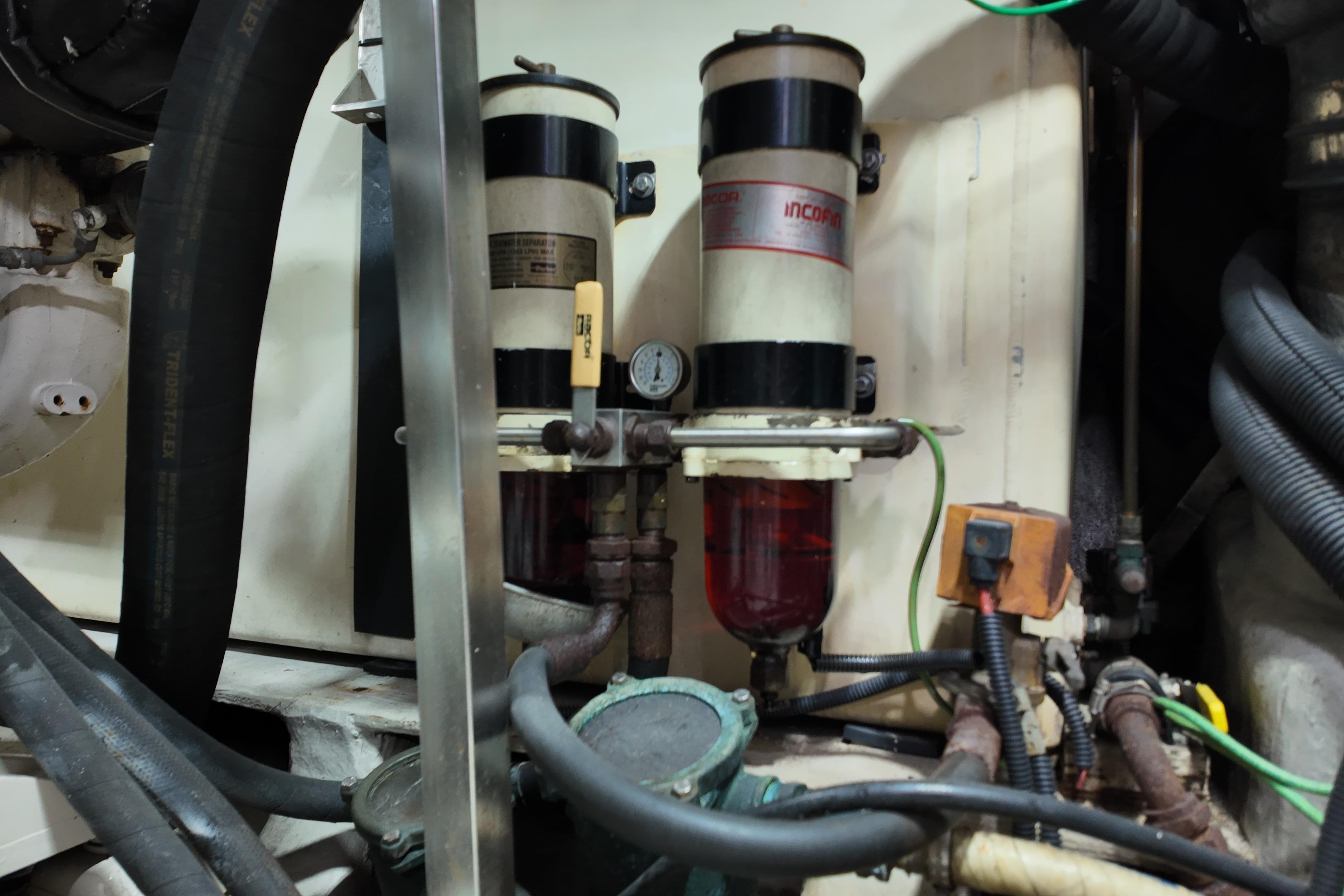 Engine room components of a 2006 Azimut 68E yacht, featuring filters and hoses.