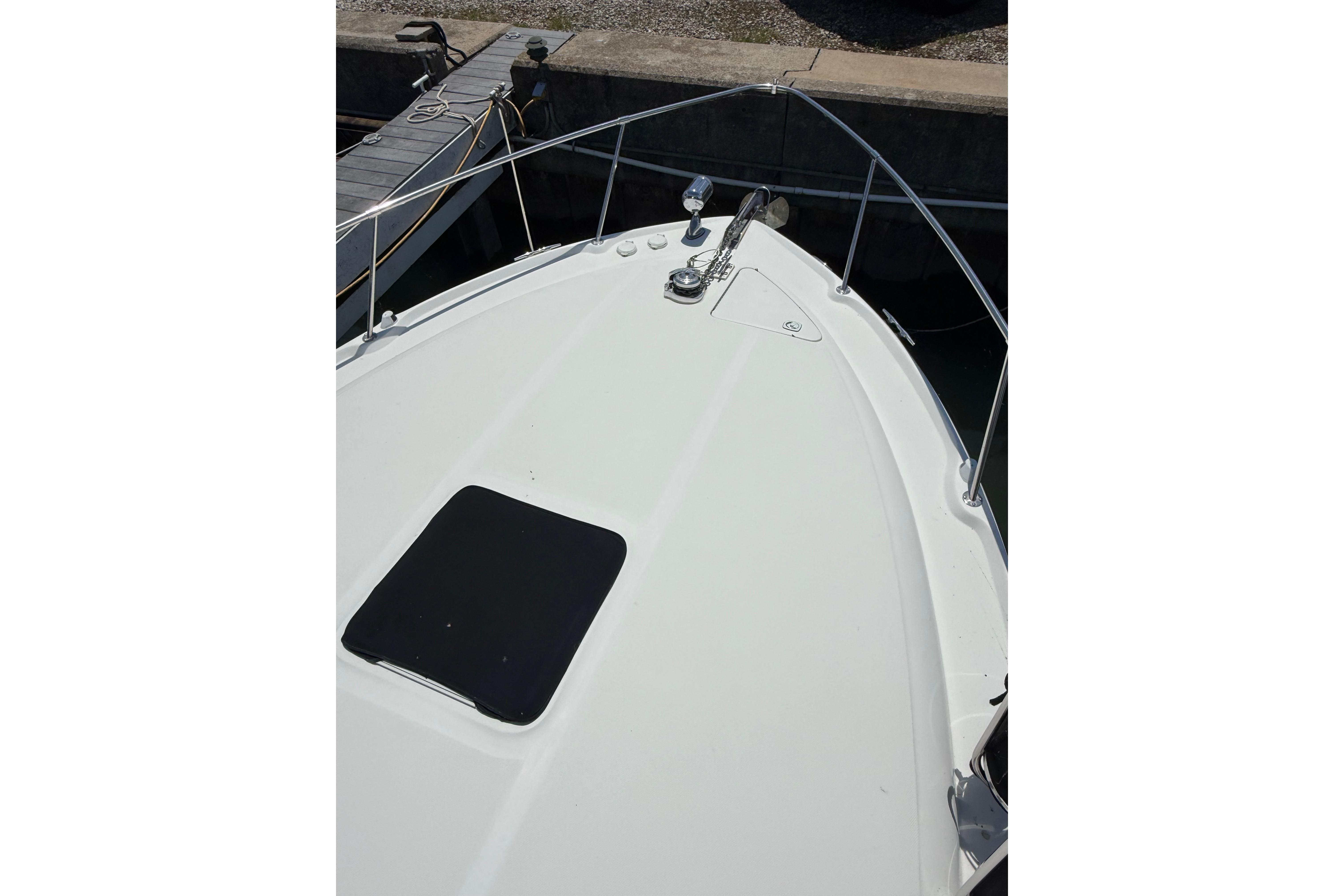 Bow view of a 1999 Sea Ray Sundancer 310 docked, featuring a sleek white deck.