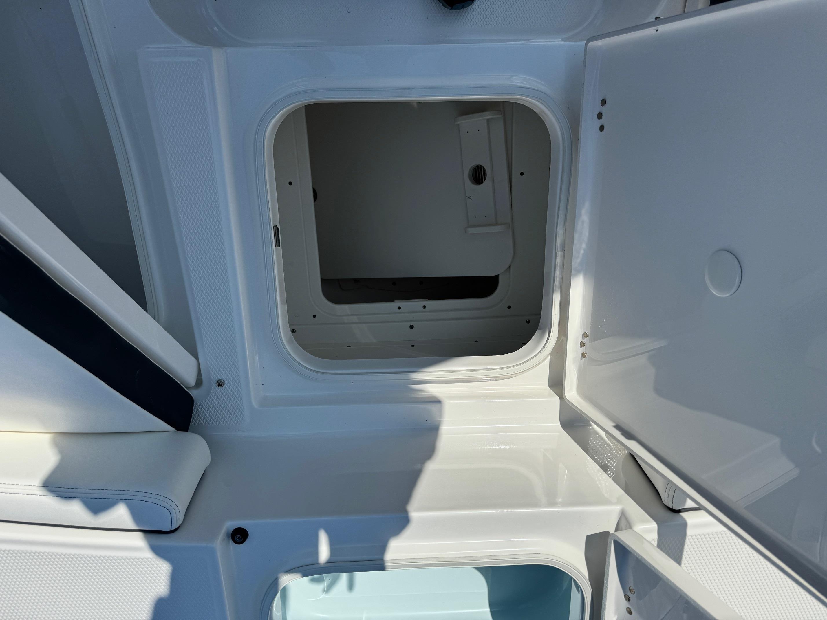 2025 Robalo R246 CAYMAN storage compartment with open hatch, showcasing interior space.
