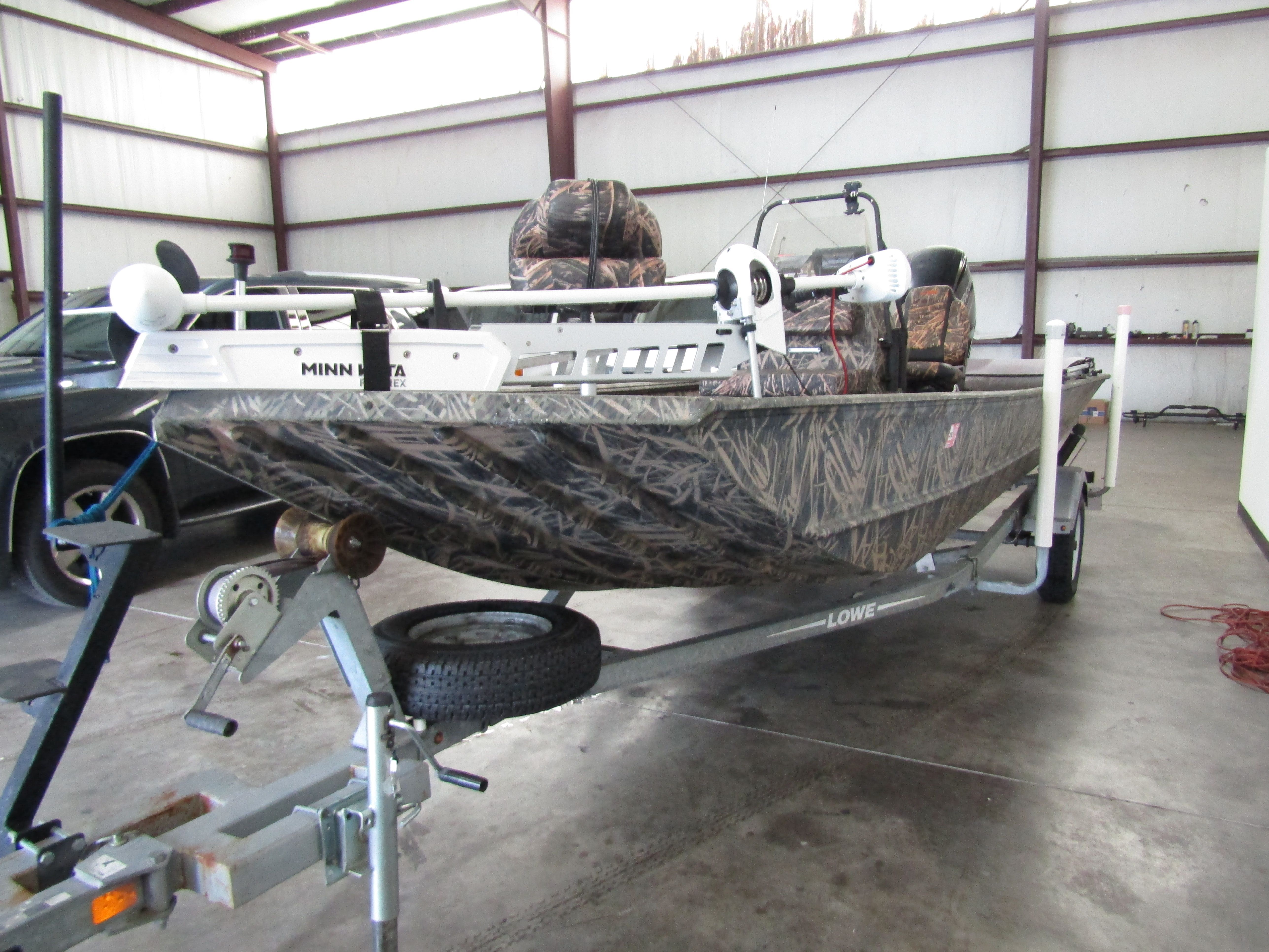 A 2016 Lowe 186 boat on a trailer inside a warehouse.