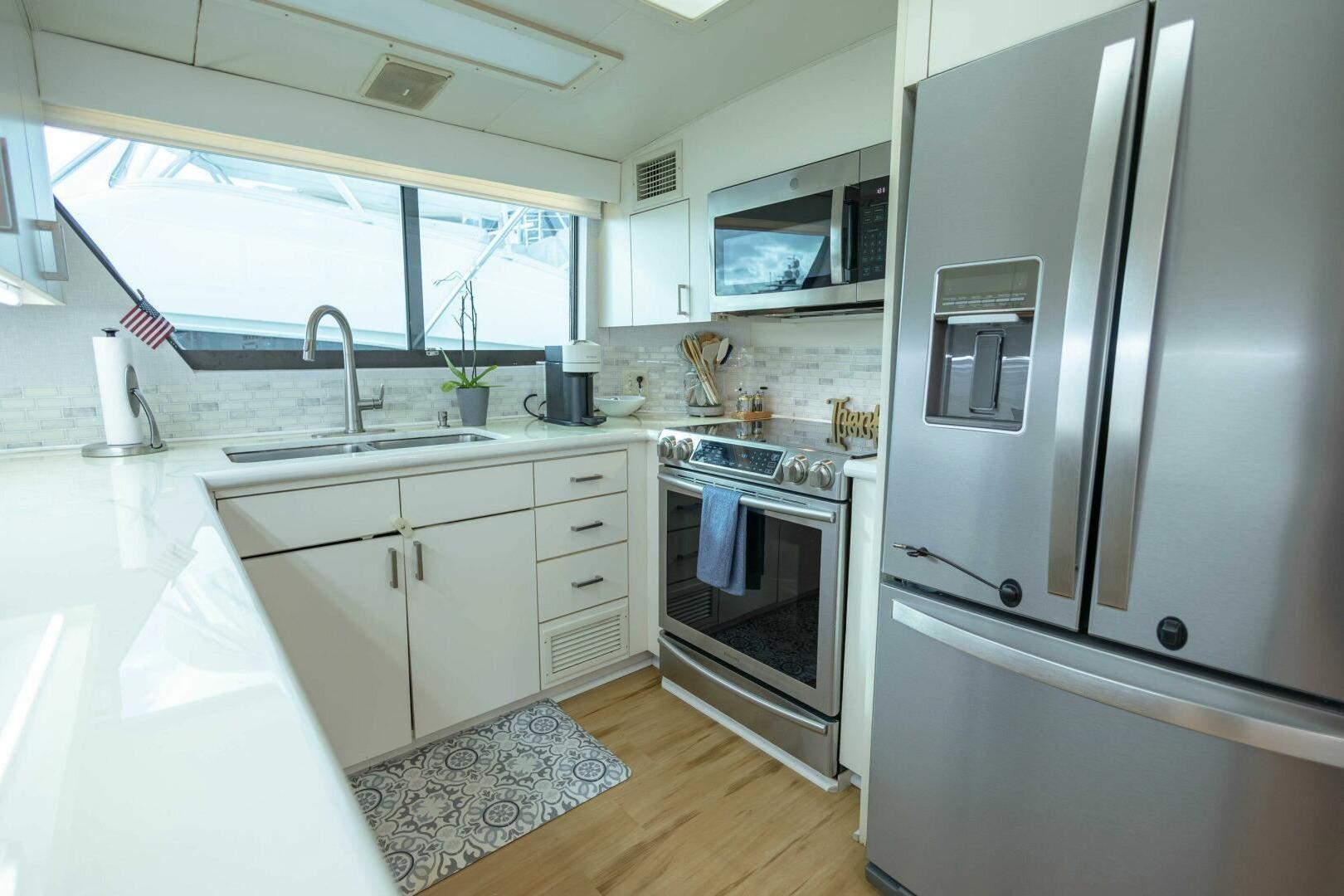 Modern kitchen in 1989 Hatteras Custom Cockpit yacht with stainless steel appliances.
