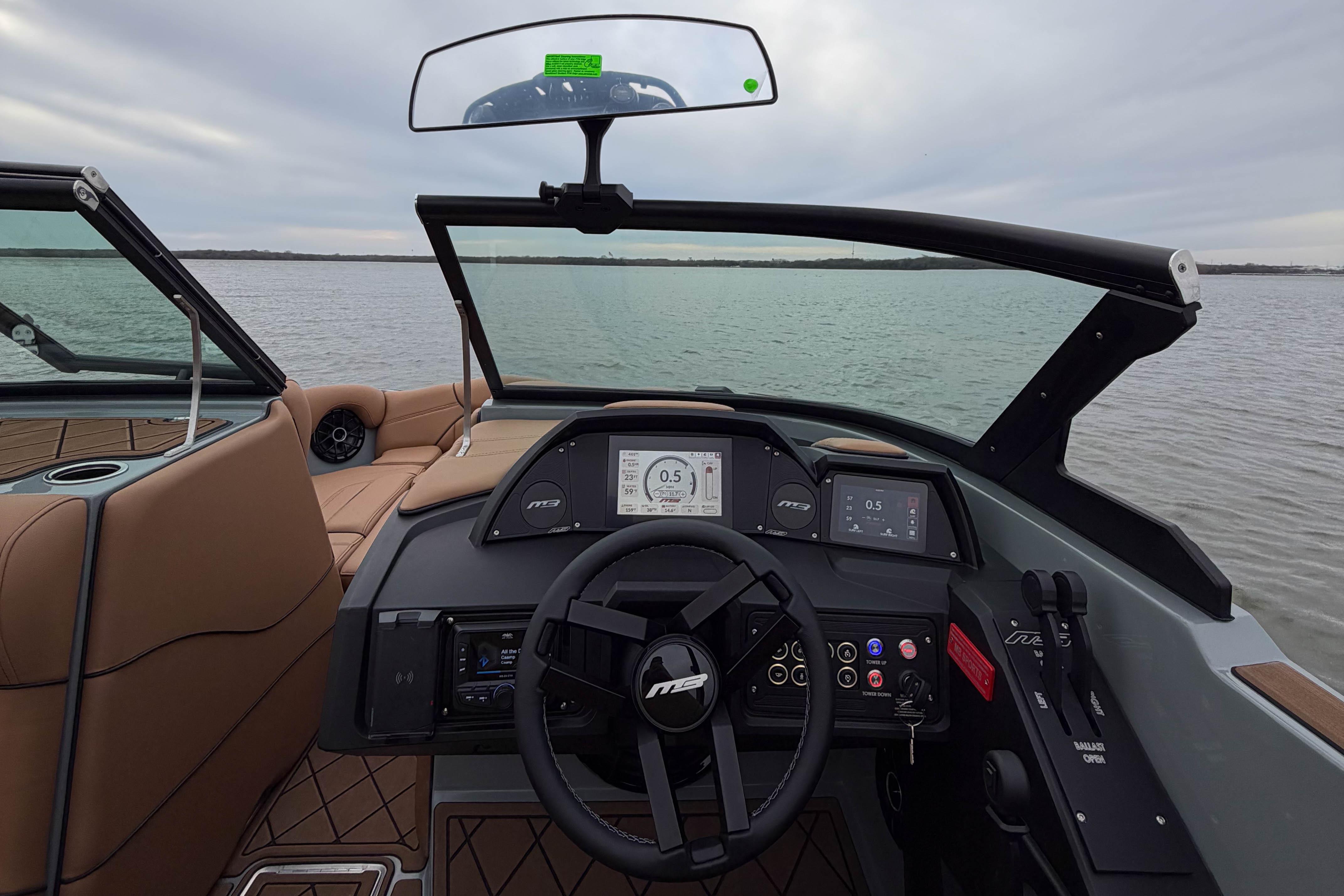 2026 MB B52 21 Alpha boat dashboard with steering wheel and digital displays on a lake.