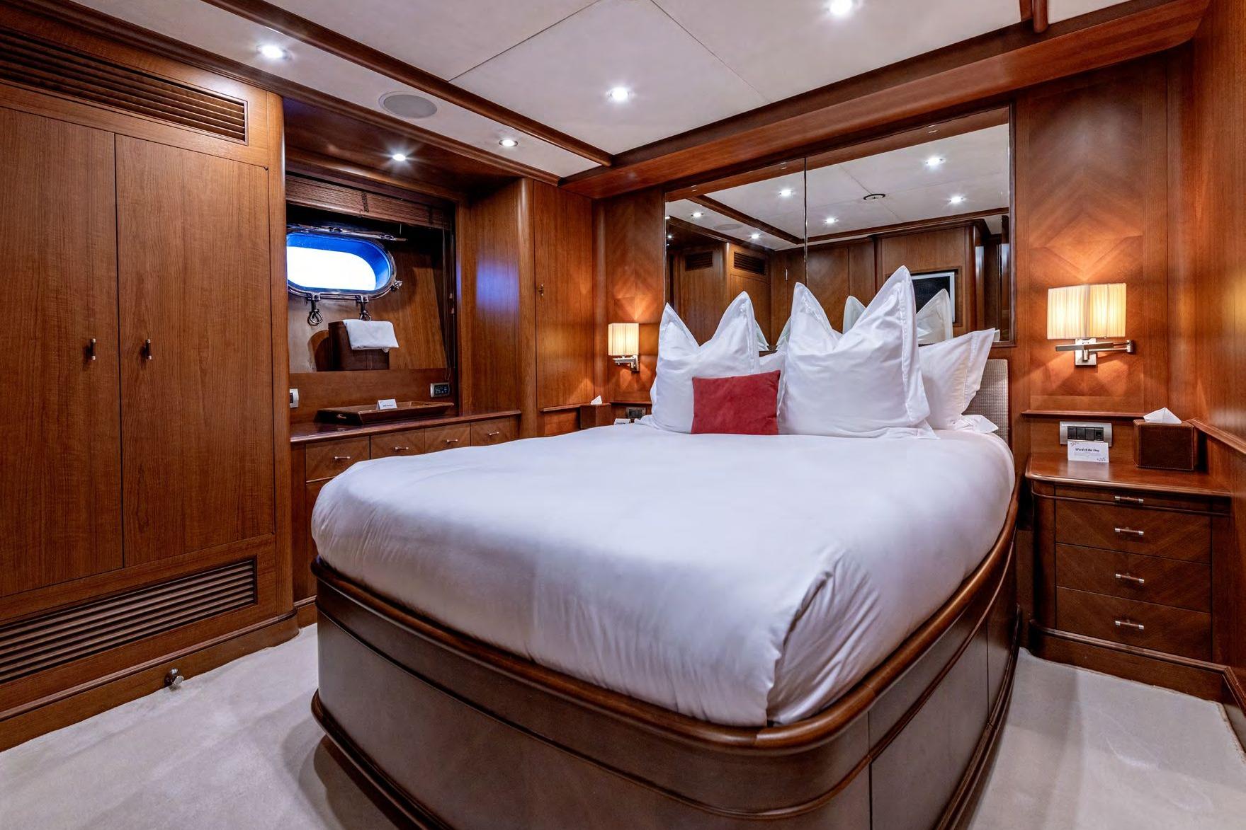 Luxurious bedroom interior on a 2006 Benetti 120 Classic yacht, featuring elegant wood finishes.