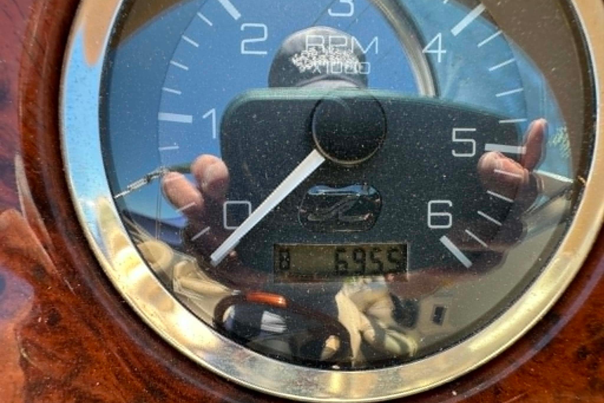 Close-up of a 2001 Sea Ray 260 Bow Rider tachometer displaying 695.9 hours.