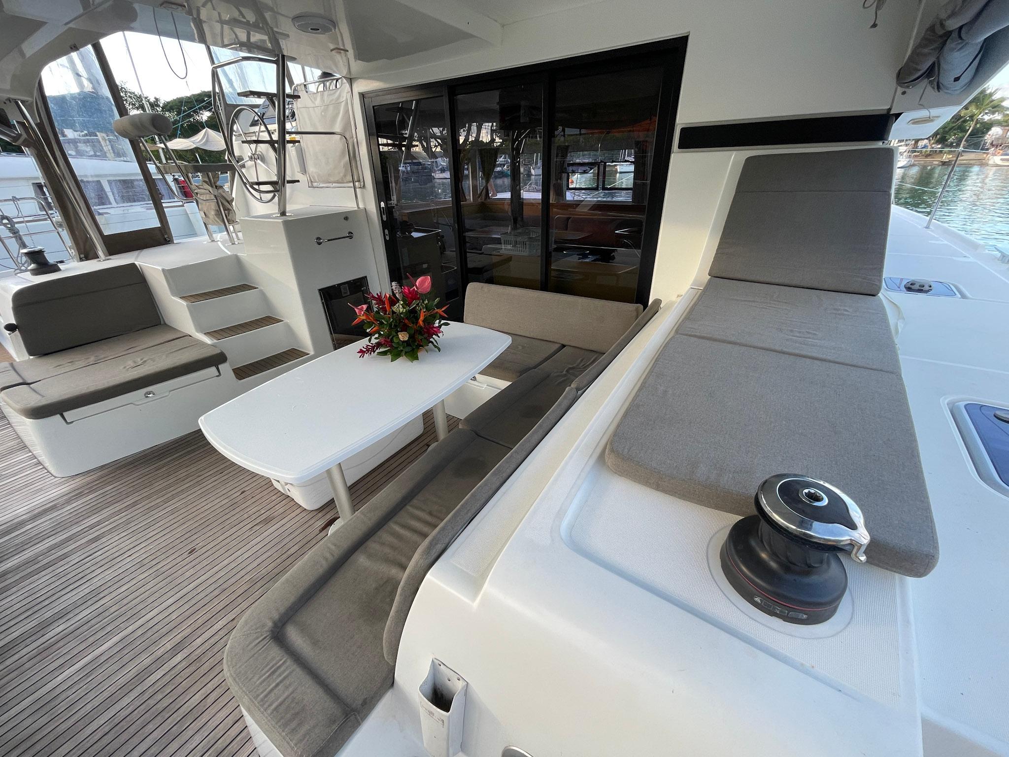 Luxurious 2016 Lagoon 42 catamaran deck with seating, table, and floral centerpiece.