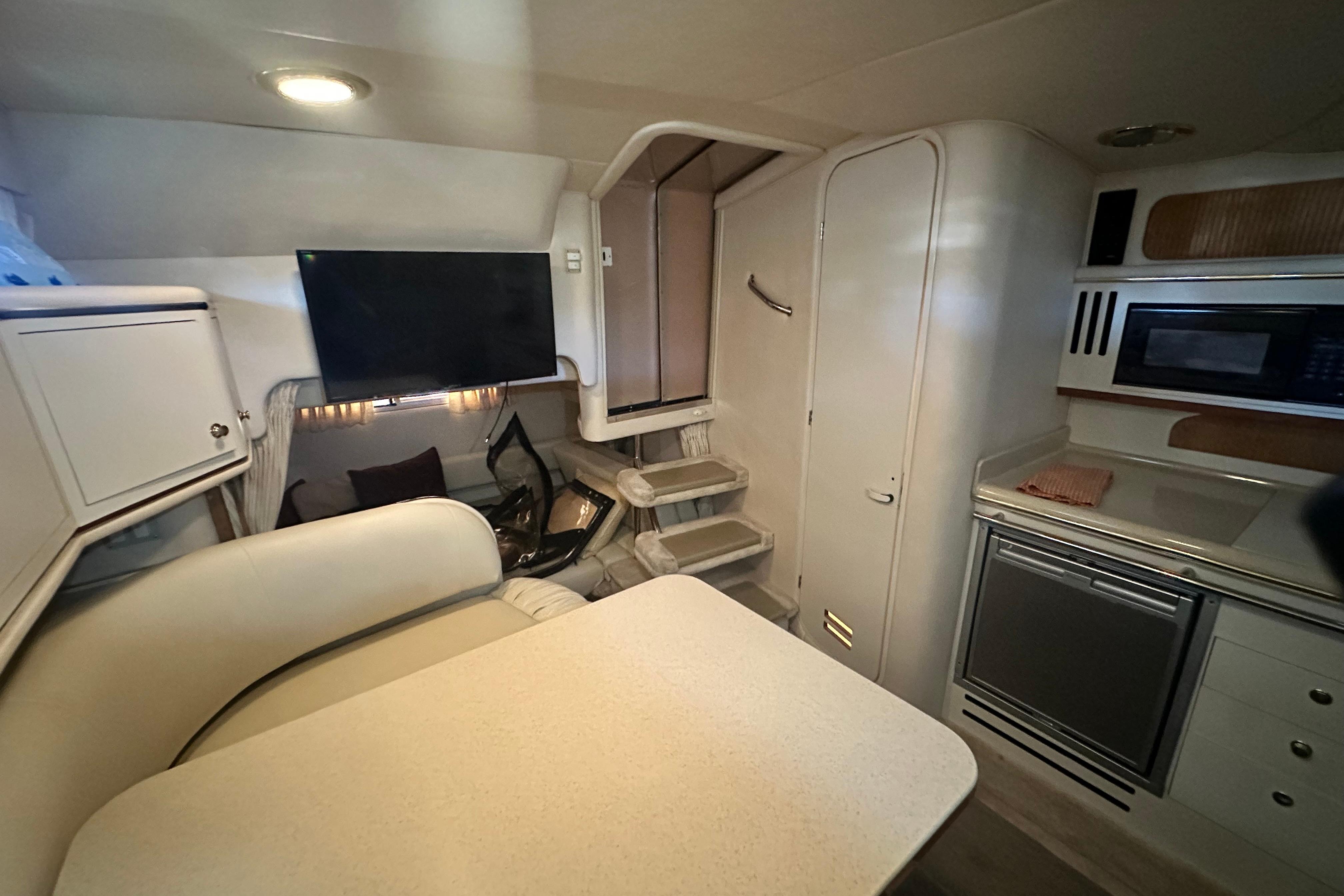 Interior of 2000 Sea Ray 310 Sundancer yacht with kitchenette and seating area.