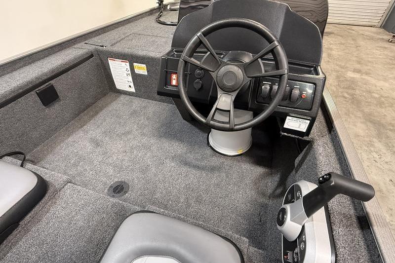 Interior of 2026 Lowe Skorpion 16 boat, featuring steering wheel and control panel.