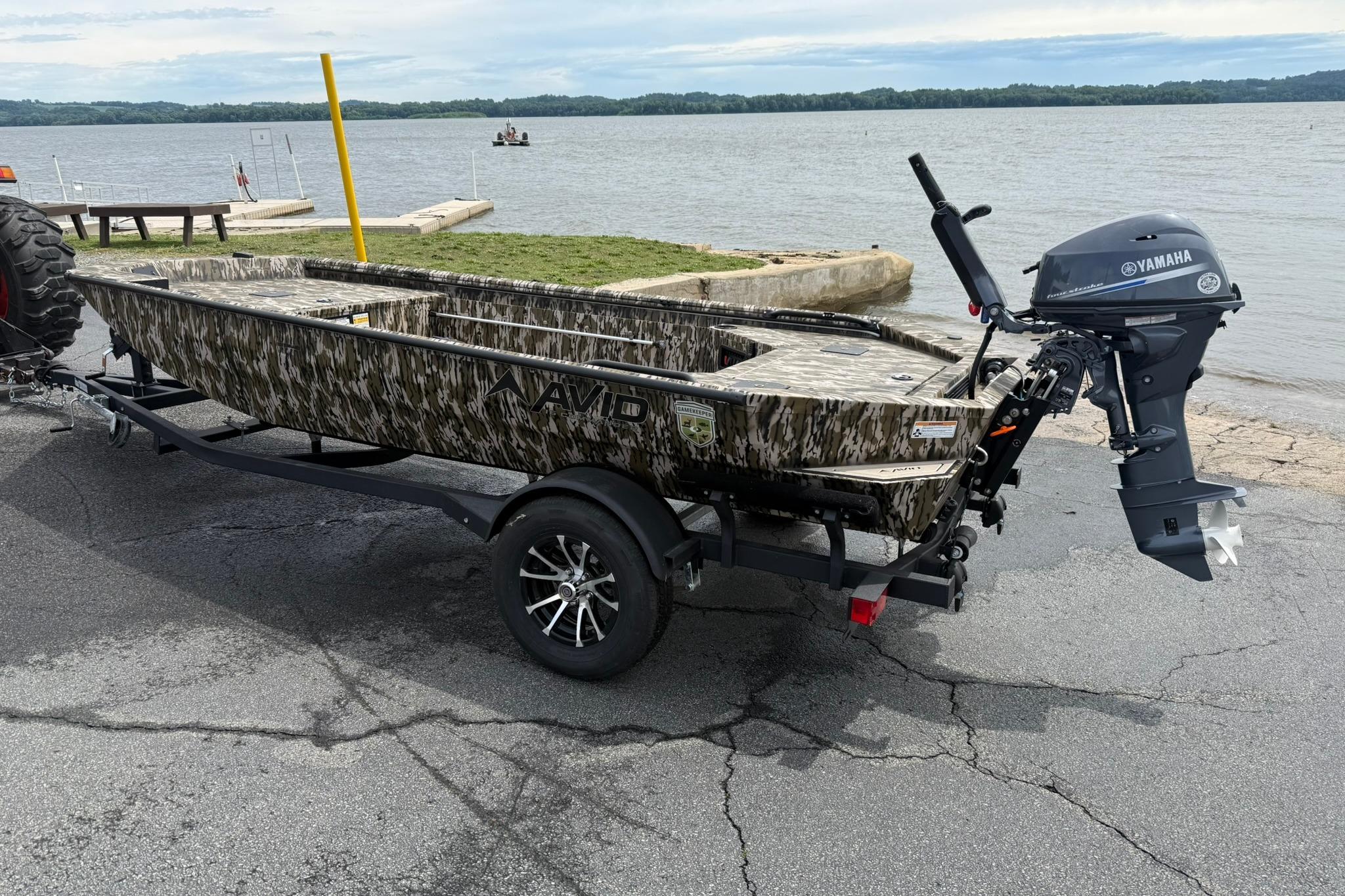 2026 Avid 16 Commander boat with Yamaha motor on trailer by lake.