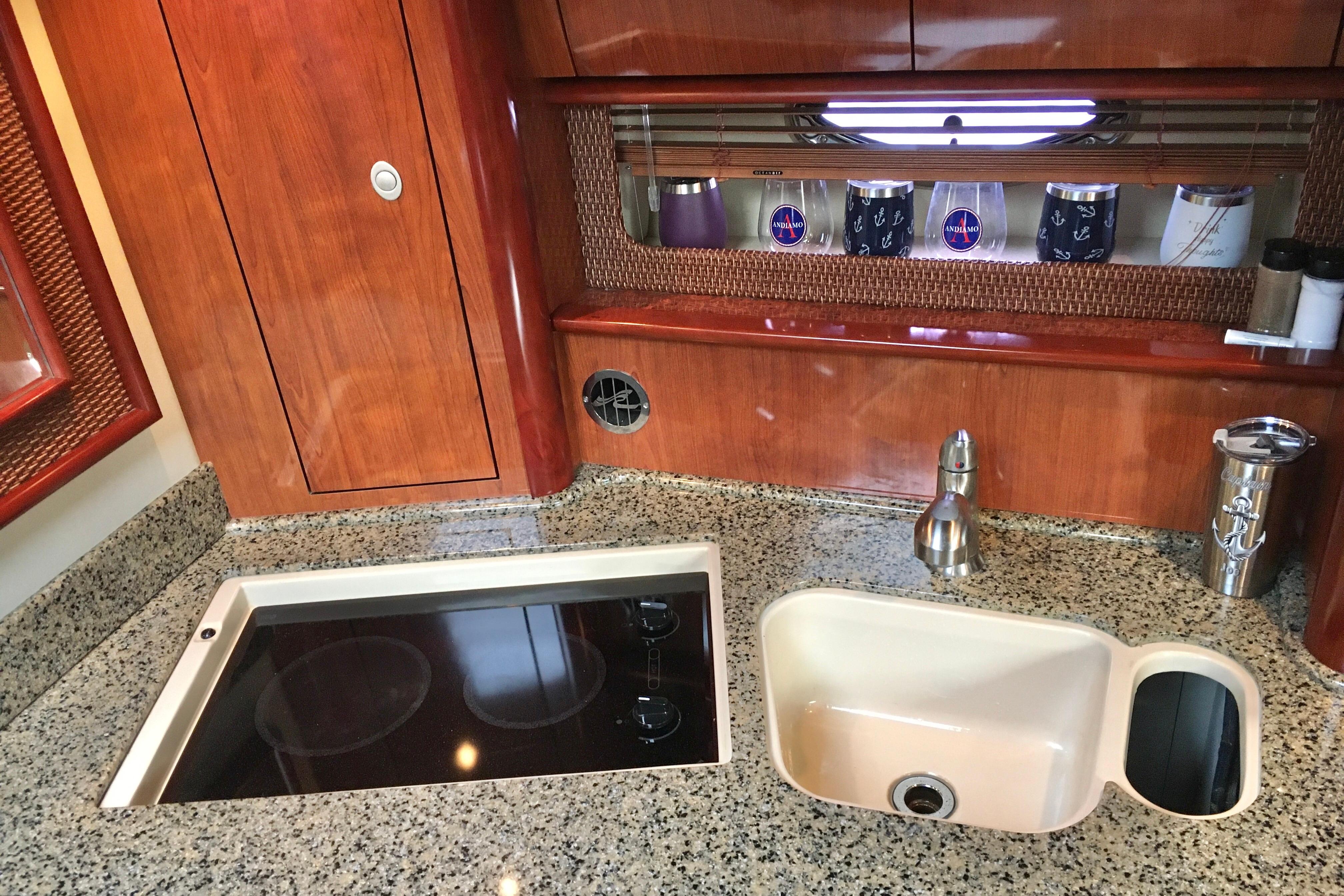 Luxurious 2005 Sea Ray 420 Sundancer yacht kitchen with granite countertops and modern appliances.