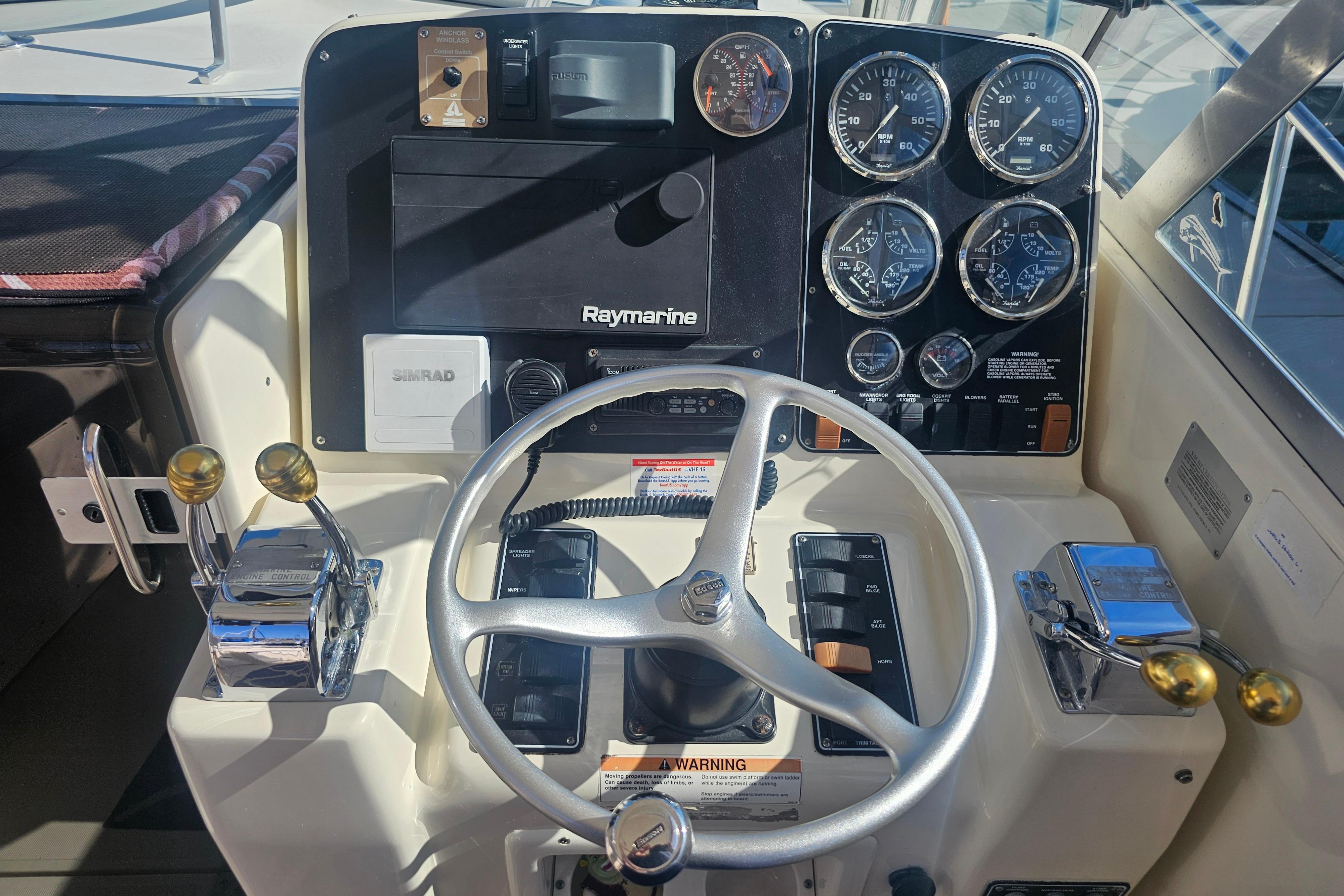 2001 Pursuit 3000 Express boat dashboard with steering wheel and control gauges.