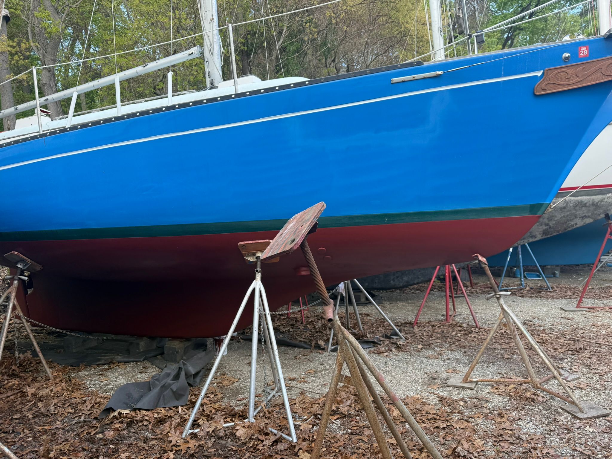 A 1976 Bayfield 30/32 sailboat is on dry dock, supported by stands.