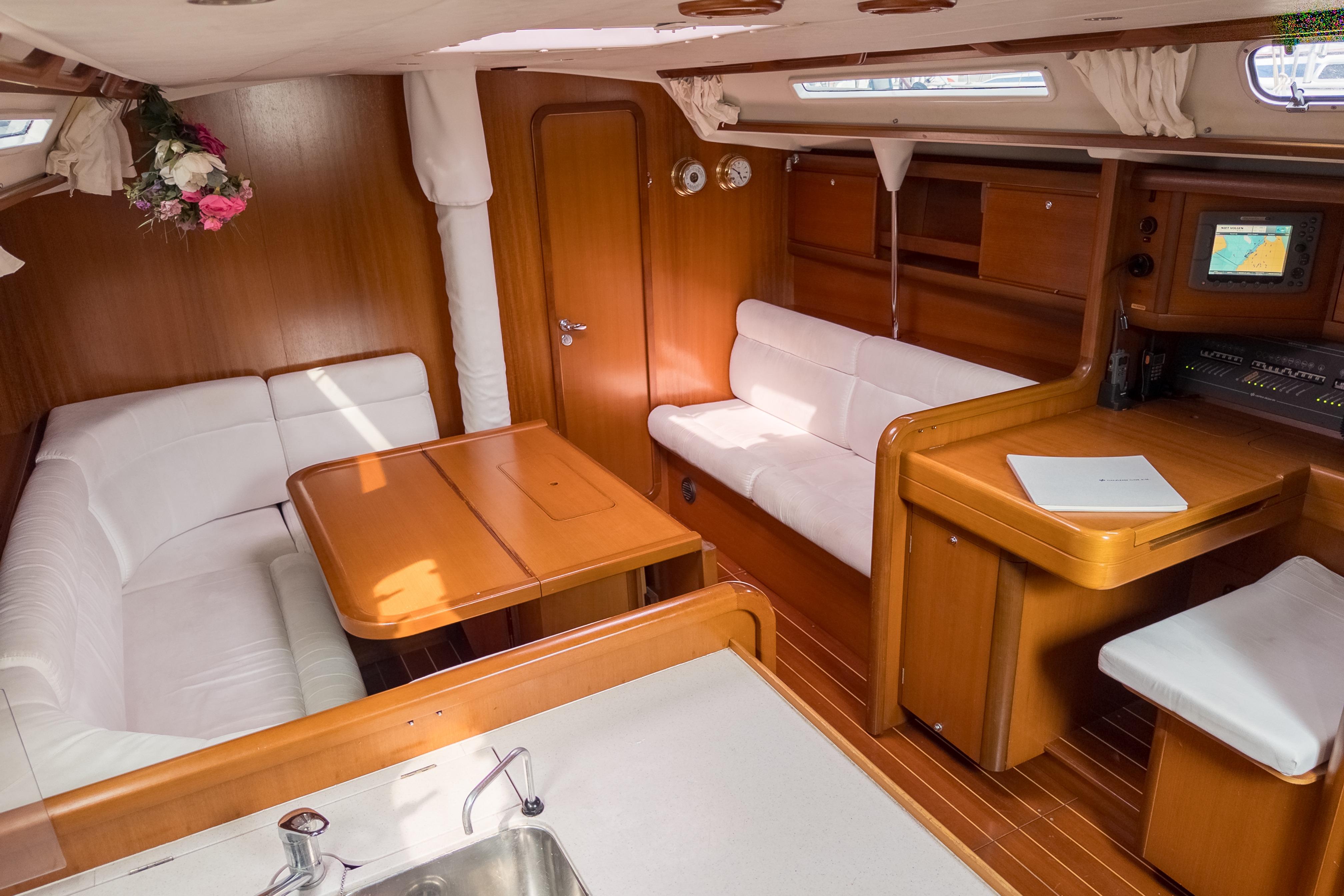 Luxurious interior of 2005 Grand Soleil 45 yacht with wooden furnishings and white seating.