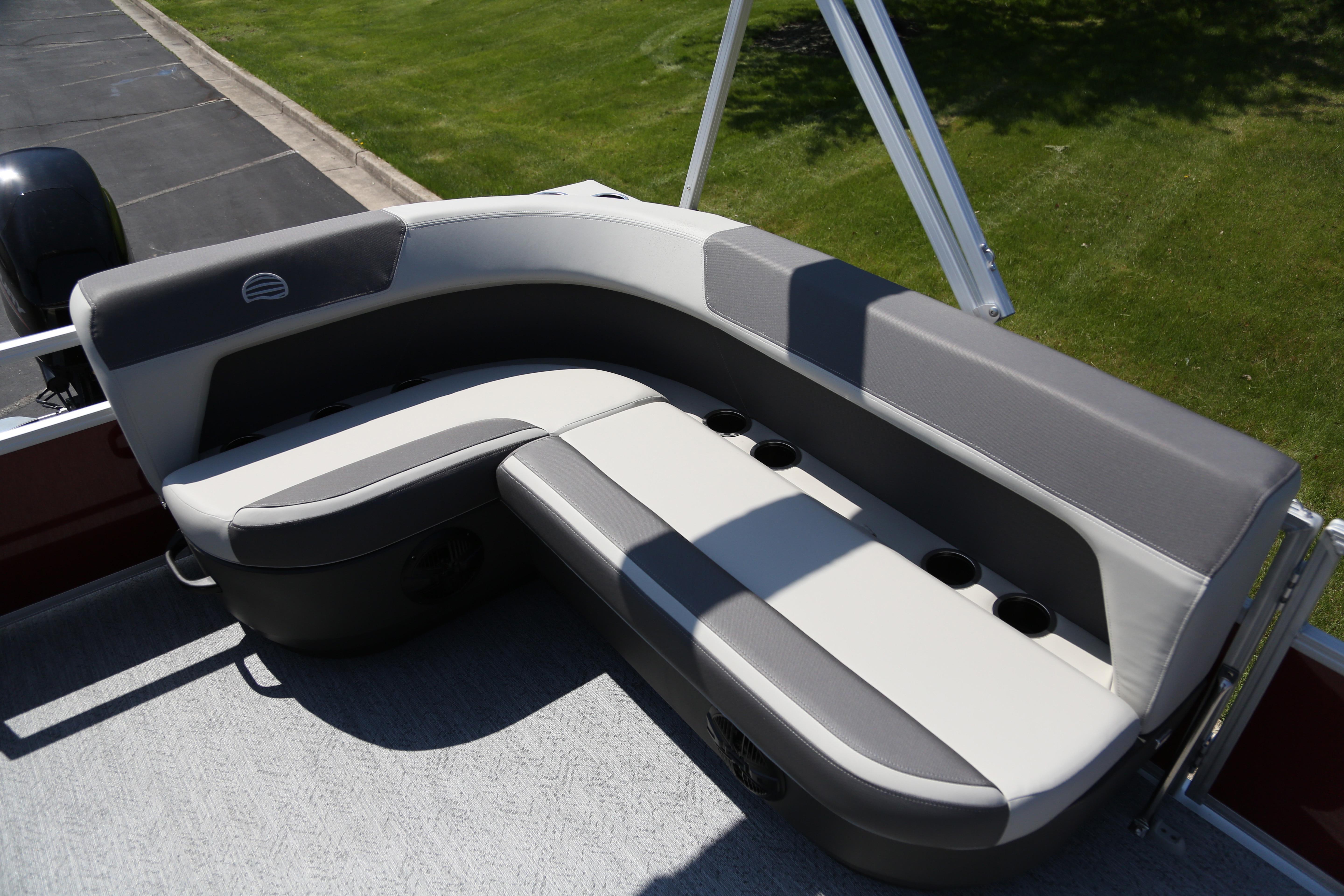 2026 Sun Tracker Bass Buggy 16 XL Select boat seating with cup holders, on a sunny day.