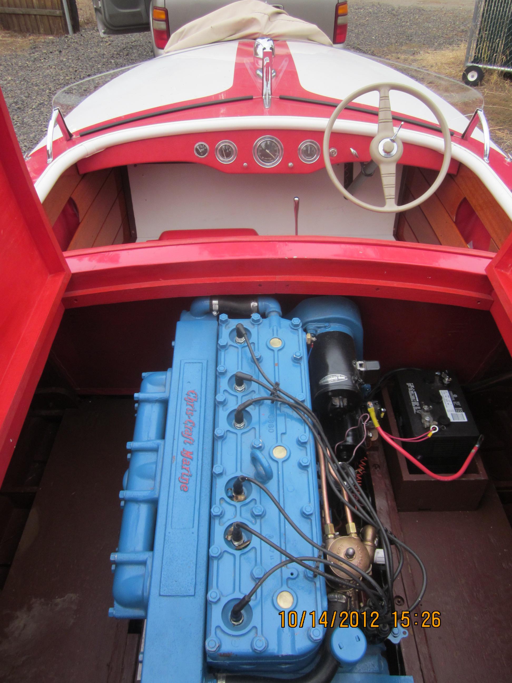 1948 Chris-Craft Racer boat interior with blue engine and red dashboard.