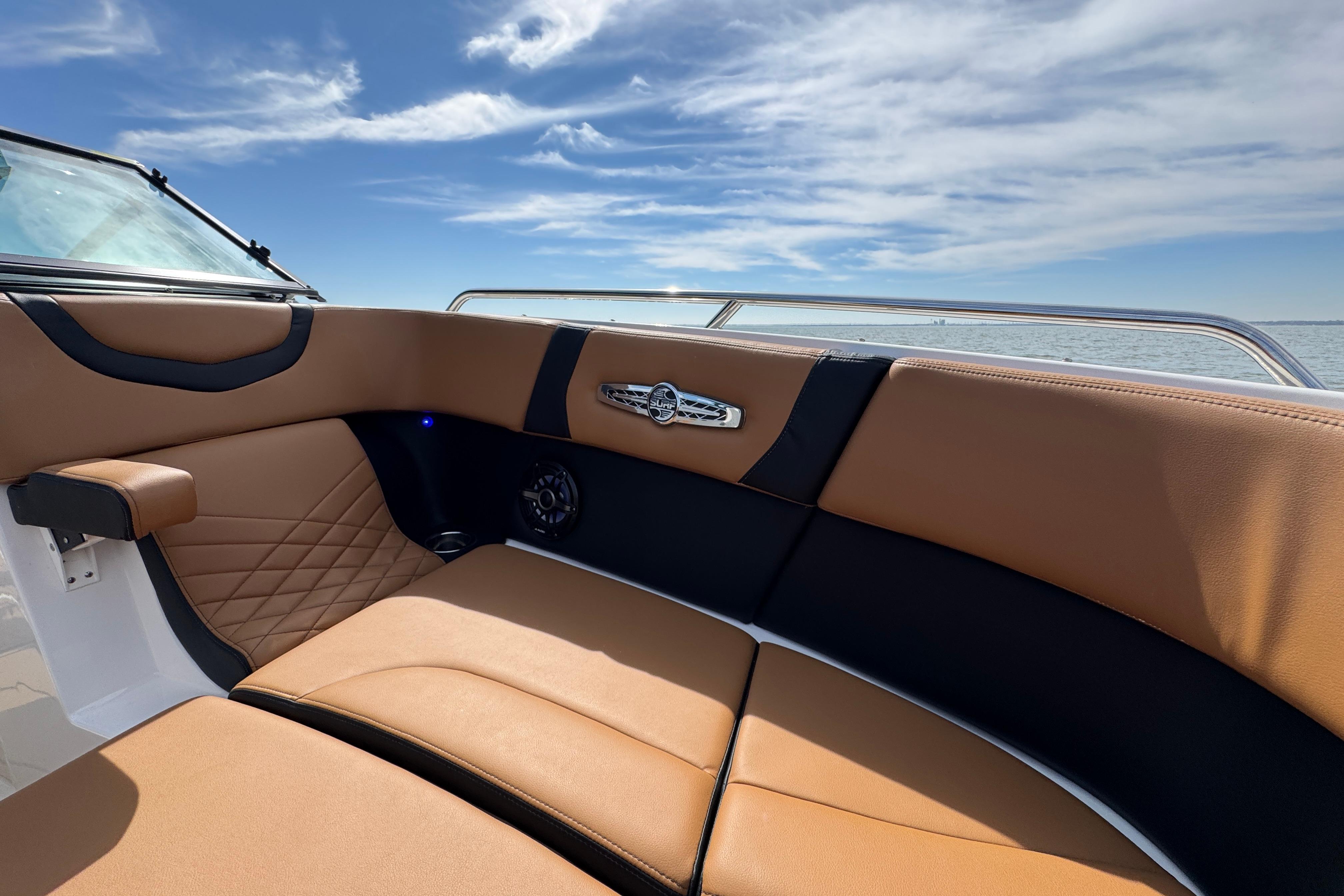 2023 Chaparral 26 Surf boat interior with tan leather seating and ocean view.