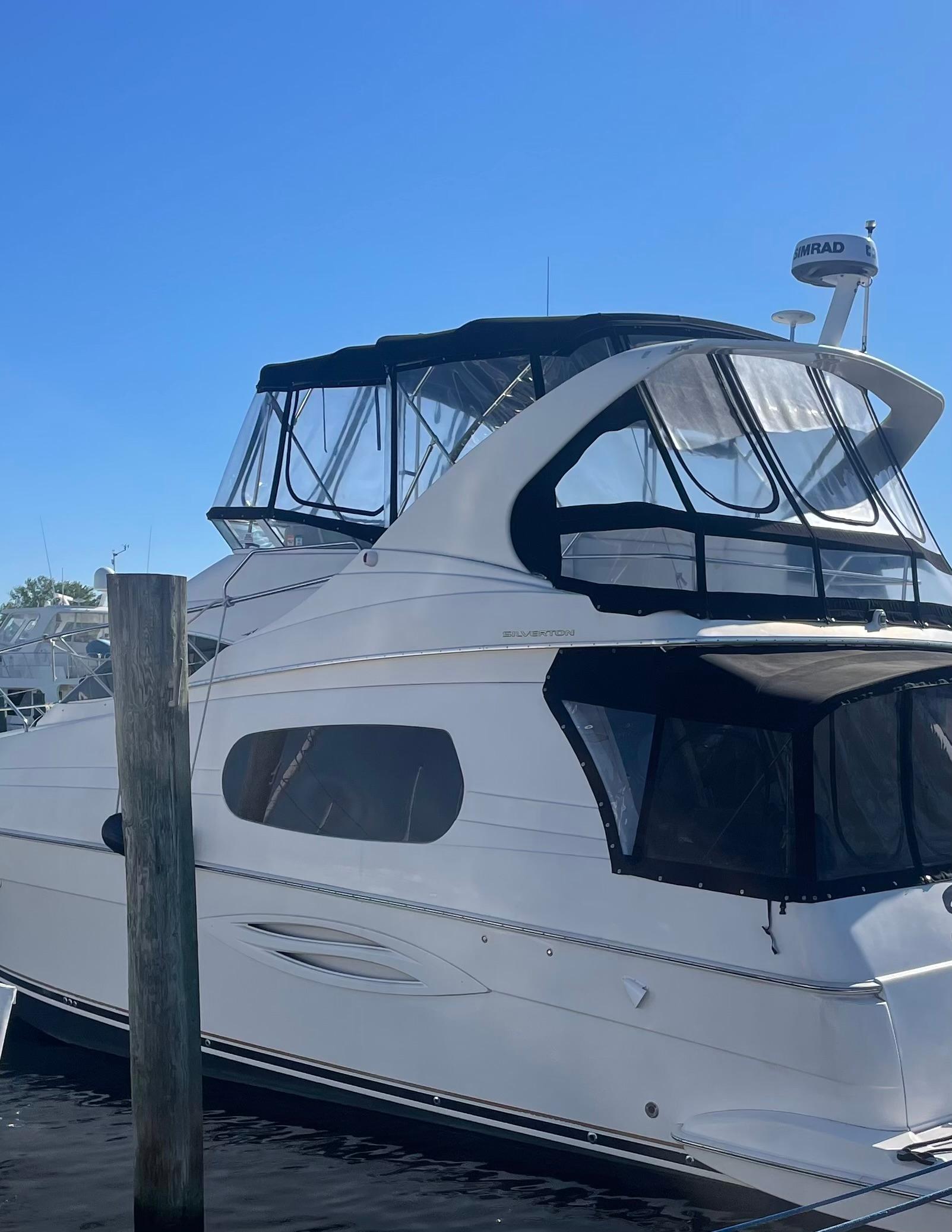 2003 Silverton 410 Sport Bridge yacht docked under clear blue sky.