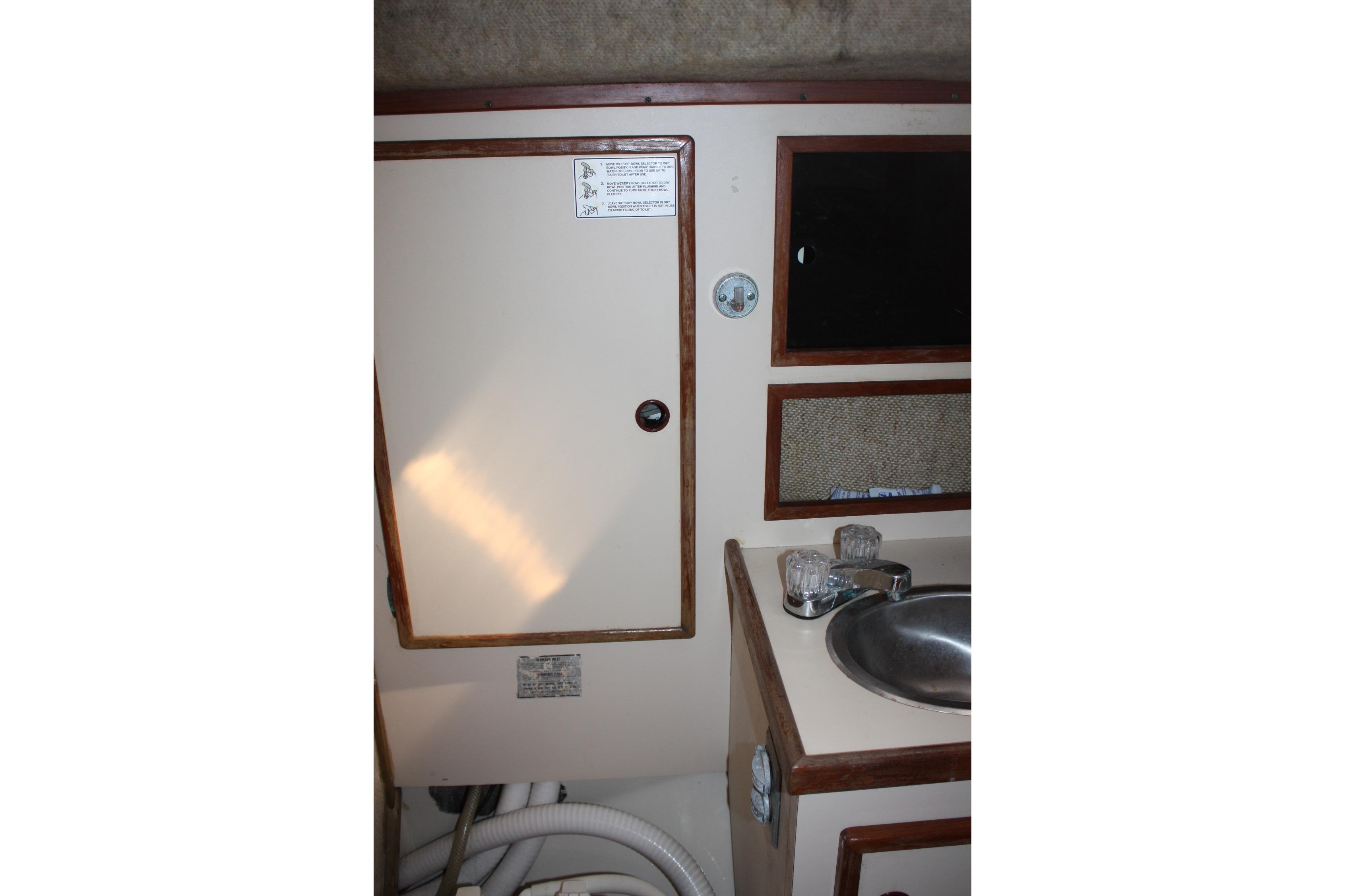 Interior of 1981 S2 9.2A sailboat showing sink, cabinet, and mirror.