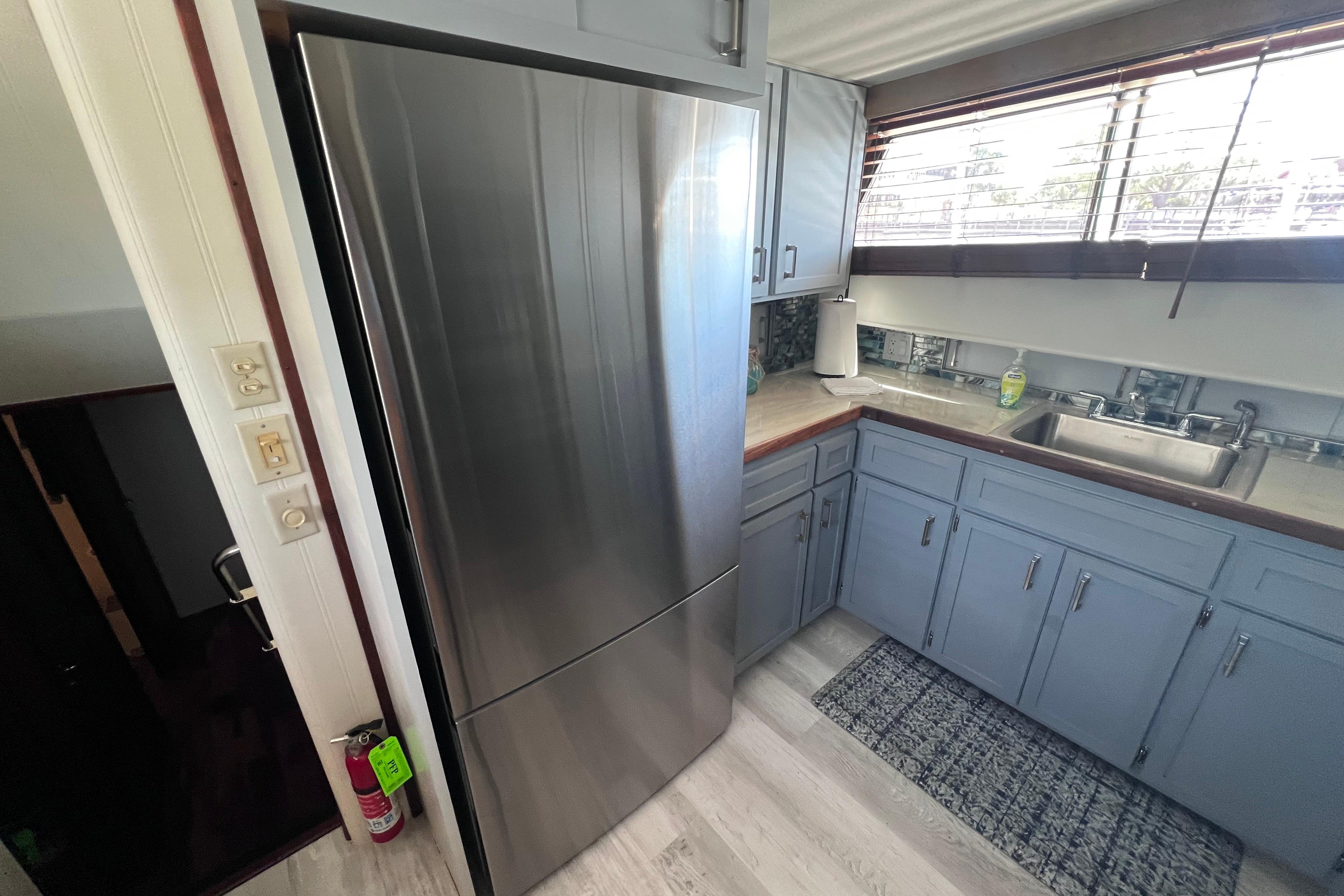 Modern kitchen interior of 1987 Hatteras 70 Cockpit Motor Yacht with stainless steel appliances.