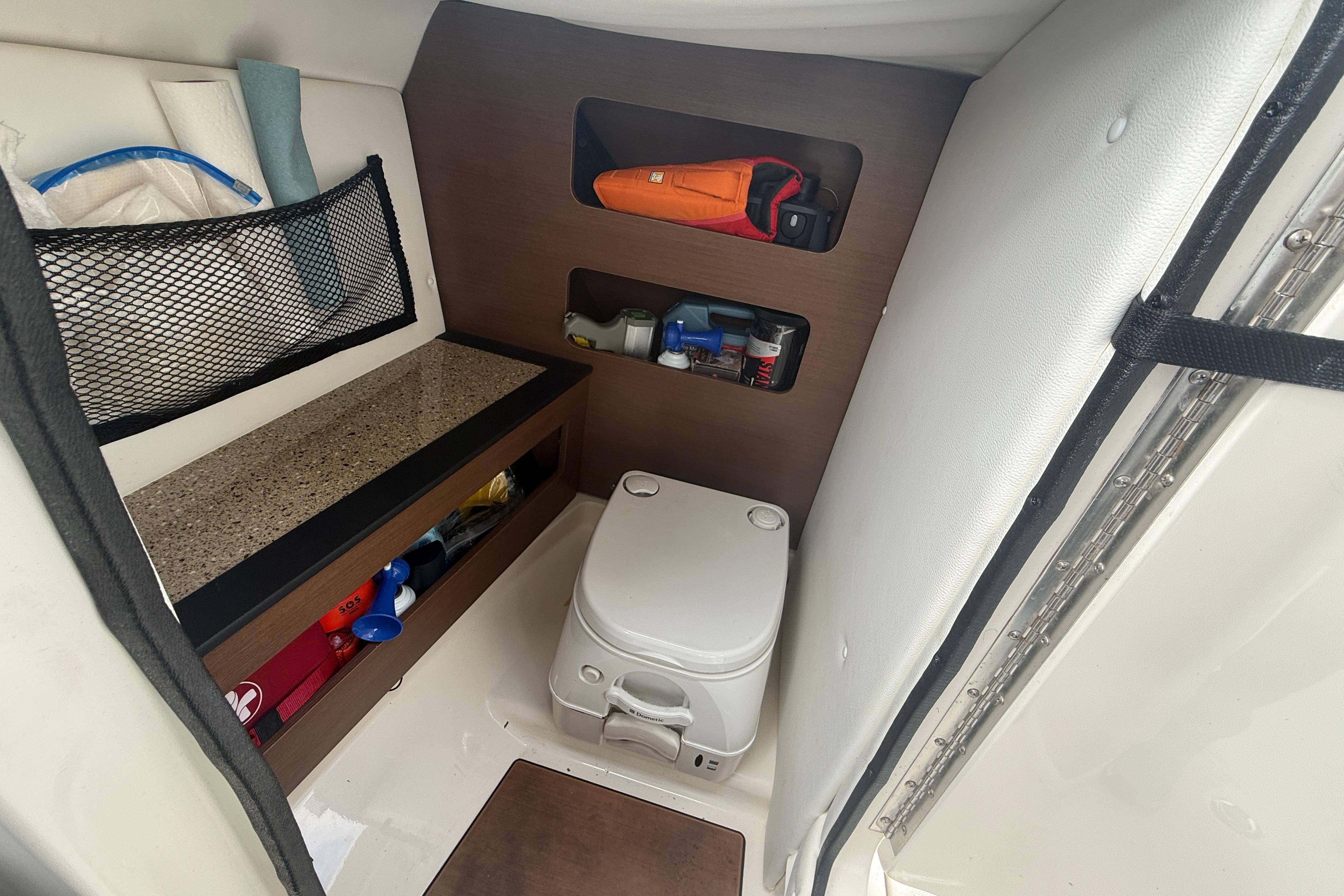 Interior of 2015 Sea Ray 240 Sundeck boat with storage and portable toilet.
