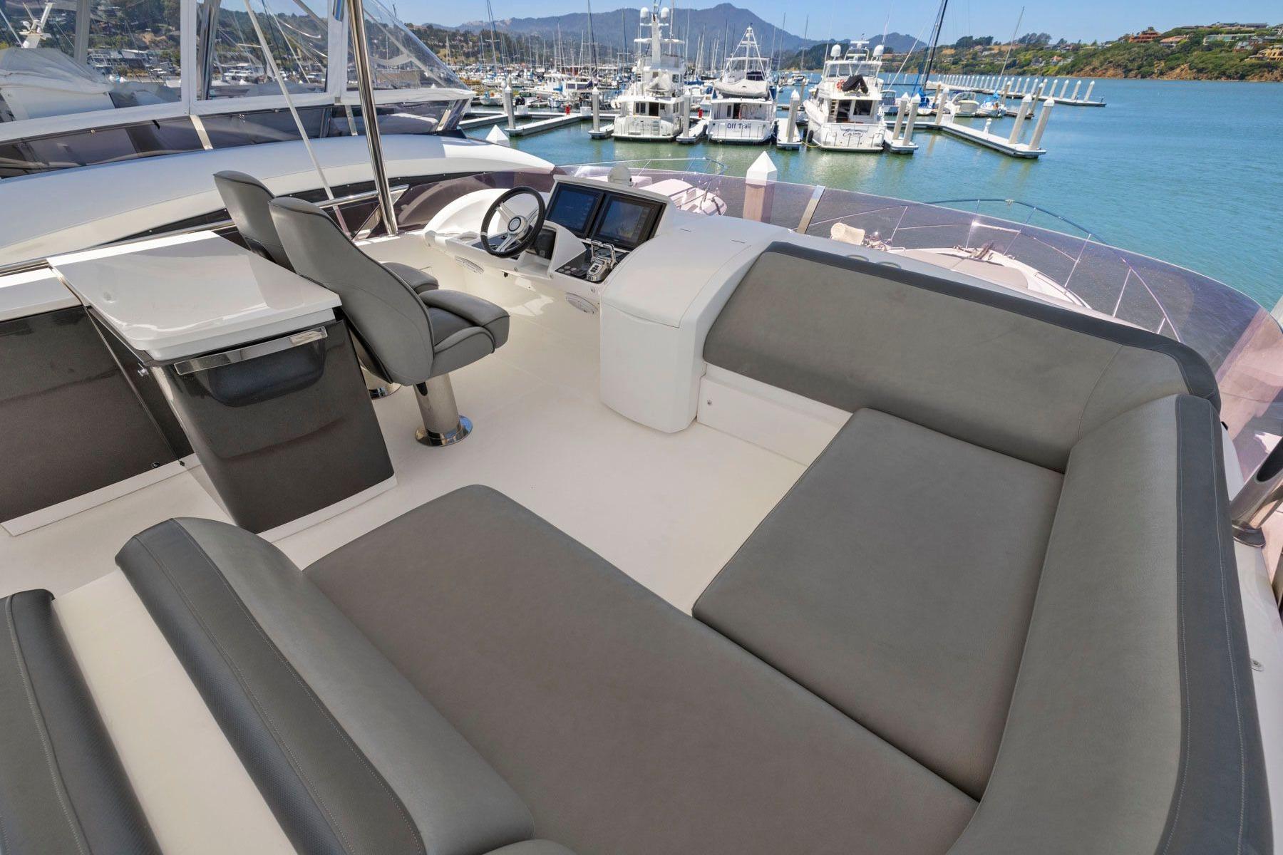 Luxurious 2015 Princess 60 Flybridge Motor Yacht interior with seating and helm, docked at marina.