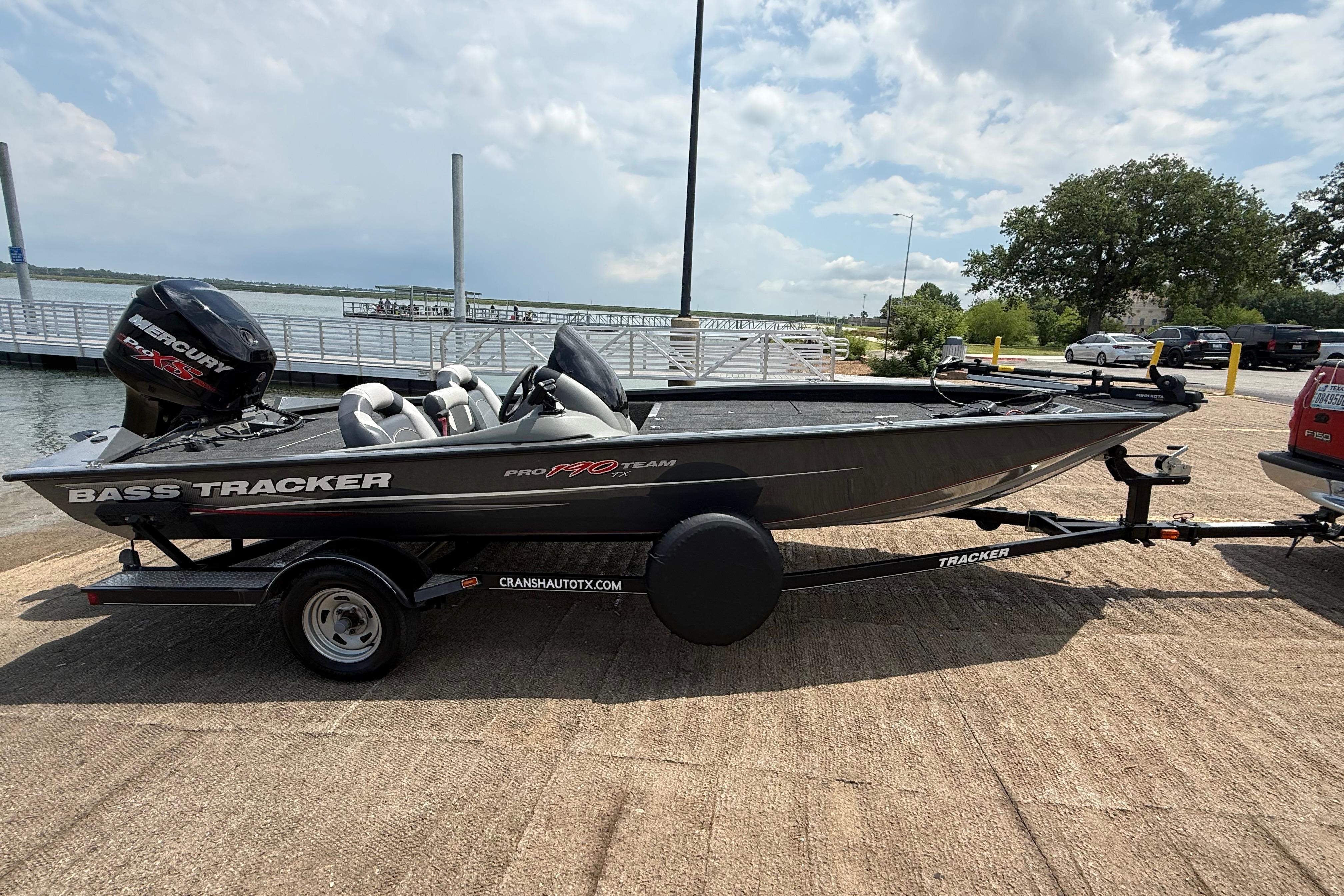 2015 Tracker Pro Team 190 TX bass boat on trailer by a lake.