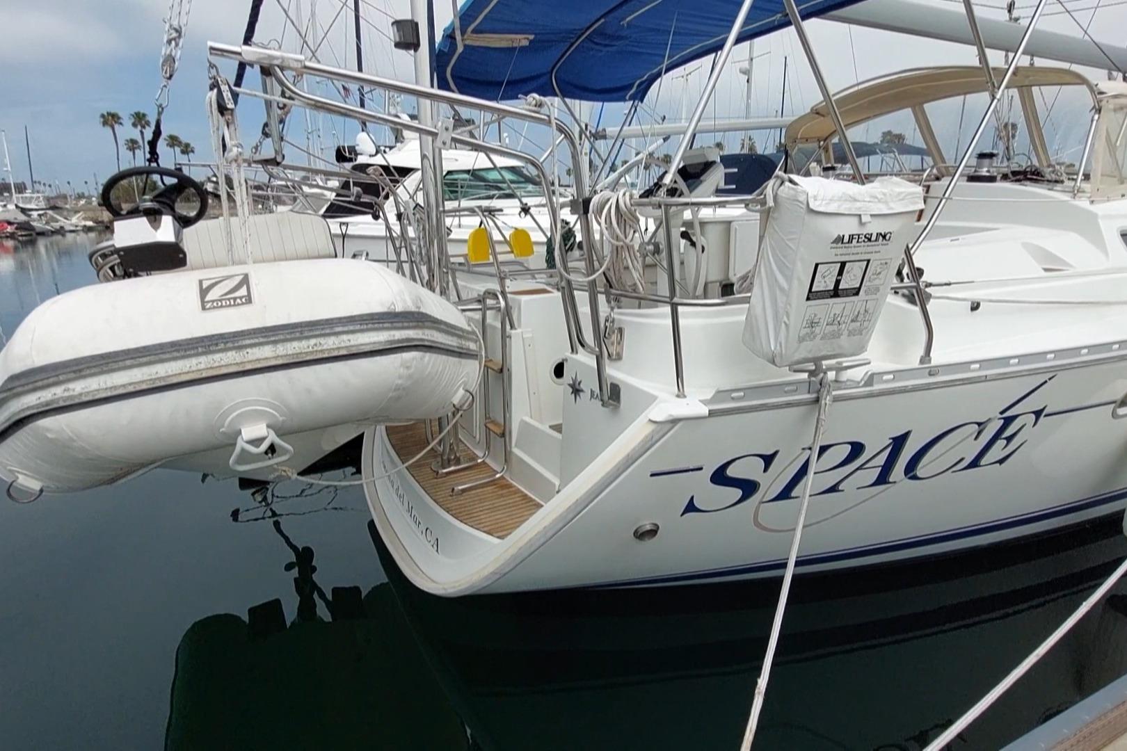 Jeanneau Sun Odyssey 43 DS sailboat, 2002 model, docked with inflatable dinghy attached.