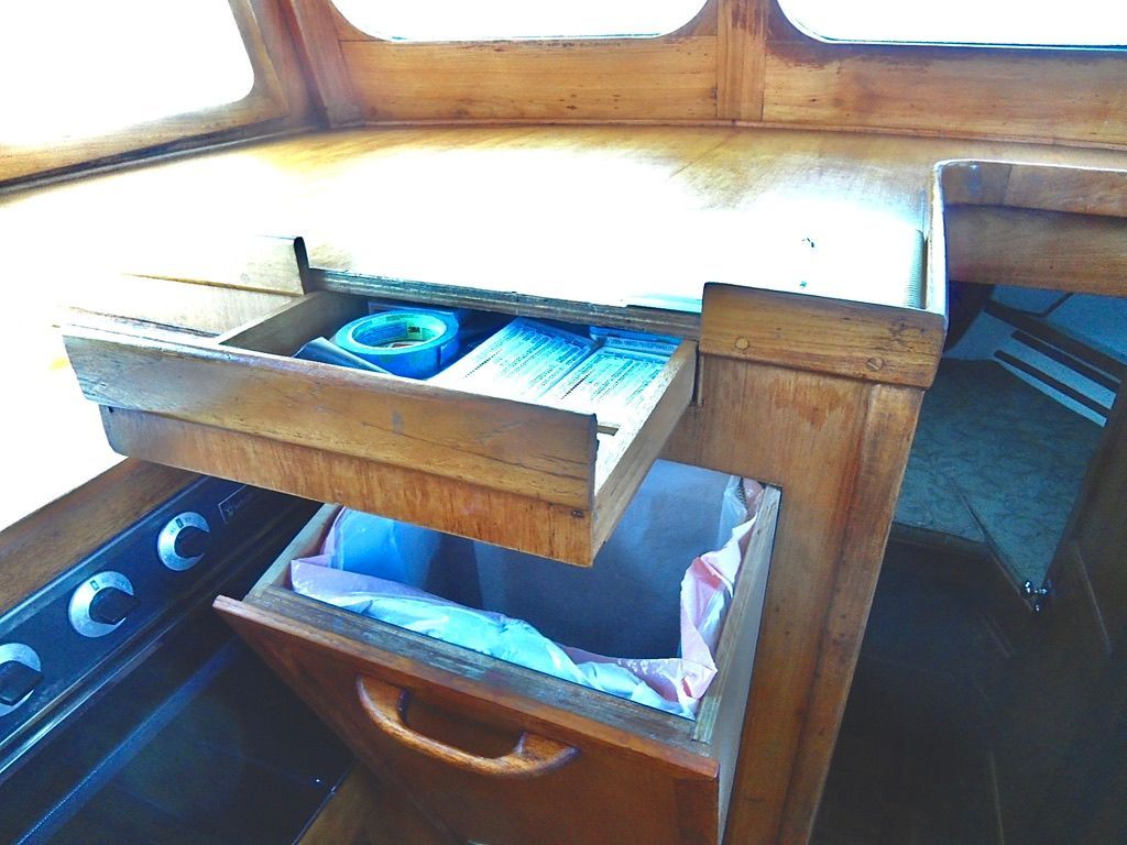1976 CHB Trawler interior with wooden cabinetry, open drawers, and visible storage.