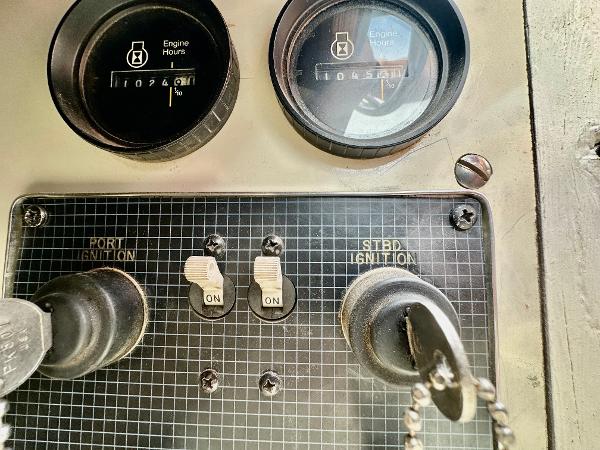 Dashboard of a 1987 Sea Ray 270 Sundancer boat with ignition switches and engine hour meters.