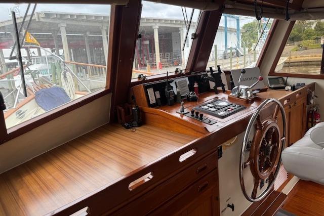 Helm of 1986 Krogen 42 Classic yacht with wooden dashboard and navigation equipment.