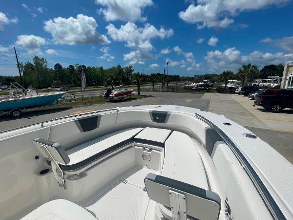 2023 Robalo R270 boat with spacious seating, docked under a clear blue sky.