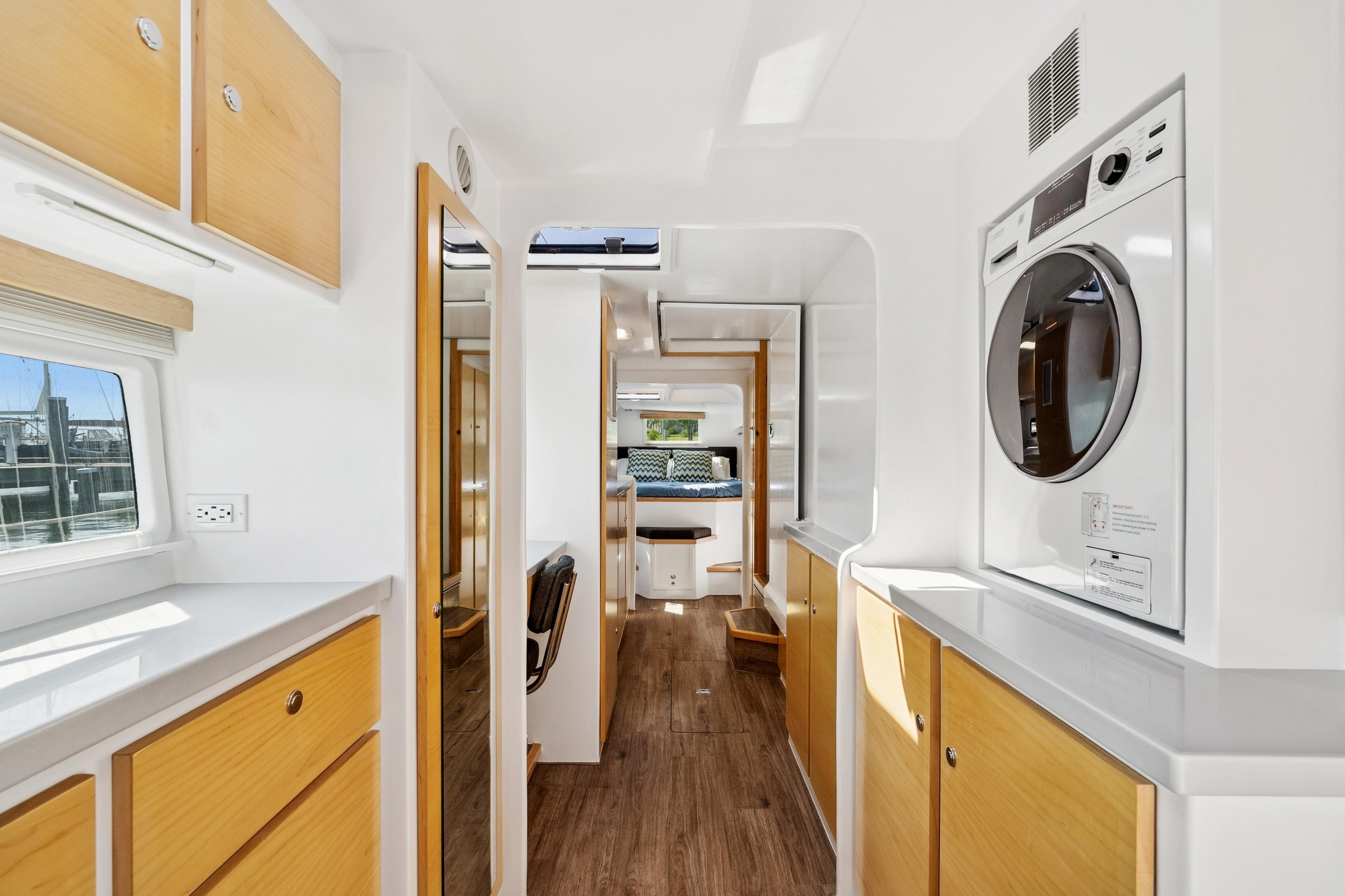 Modern interior of 2024 St Francis 460 yacht with wood accents and washer-dryer unit.