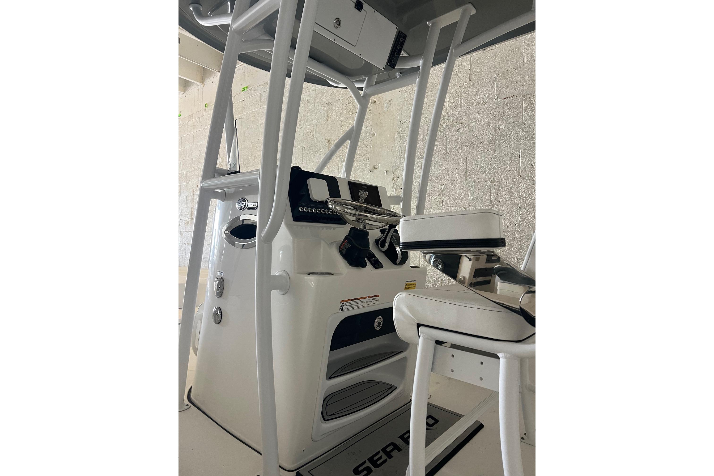 2024 Sea Pro 230 Bay boat interior with steering console and seating.