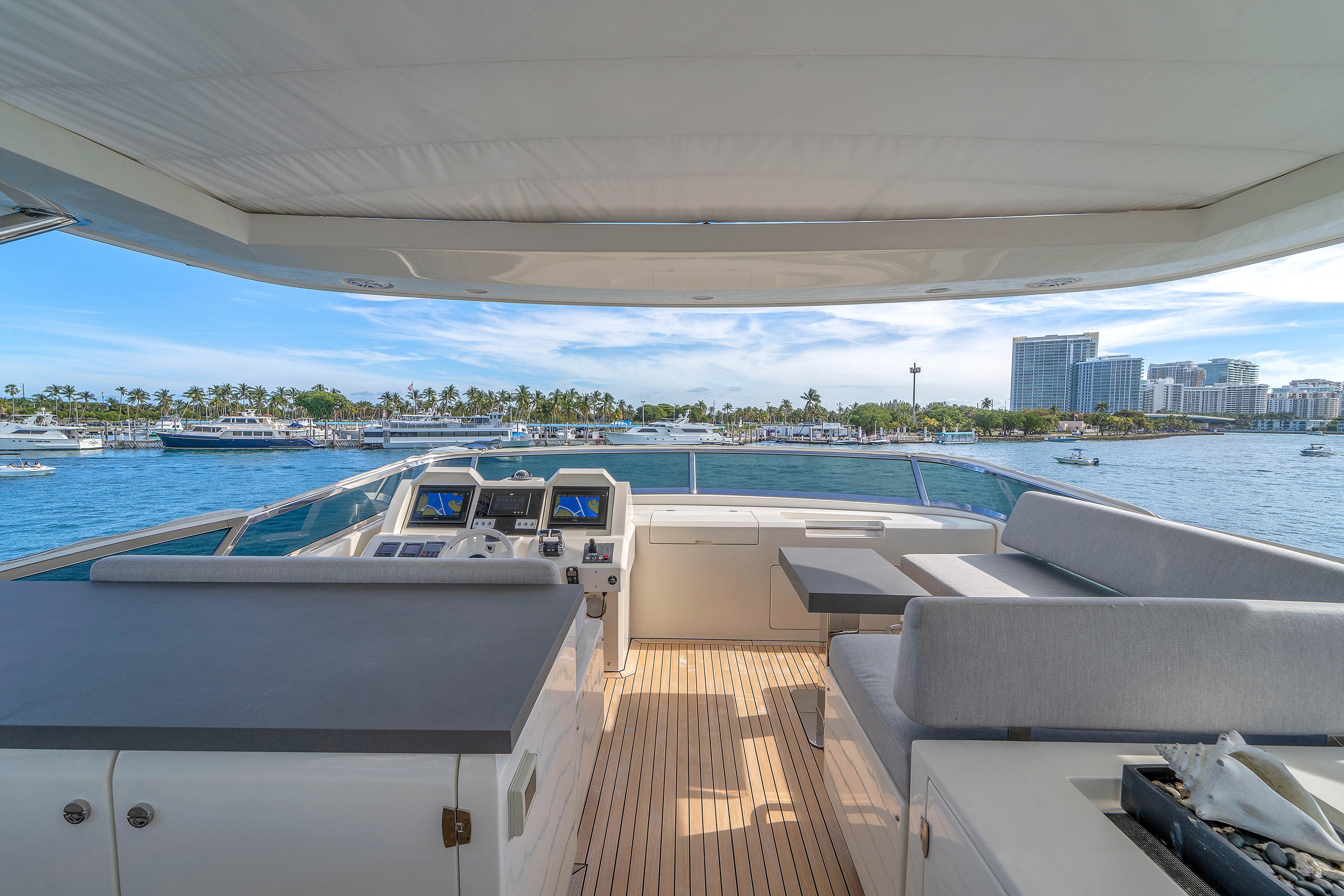 Luxurious 2010 Azimut 95 yacht deck with scenic waterfront view and modern seating area.