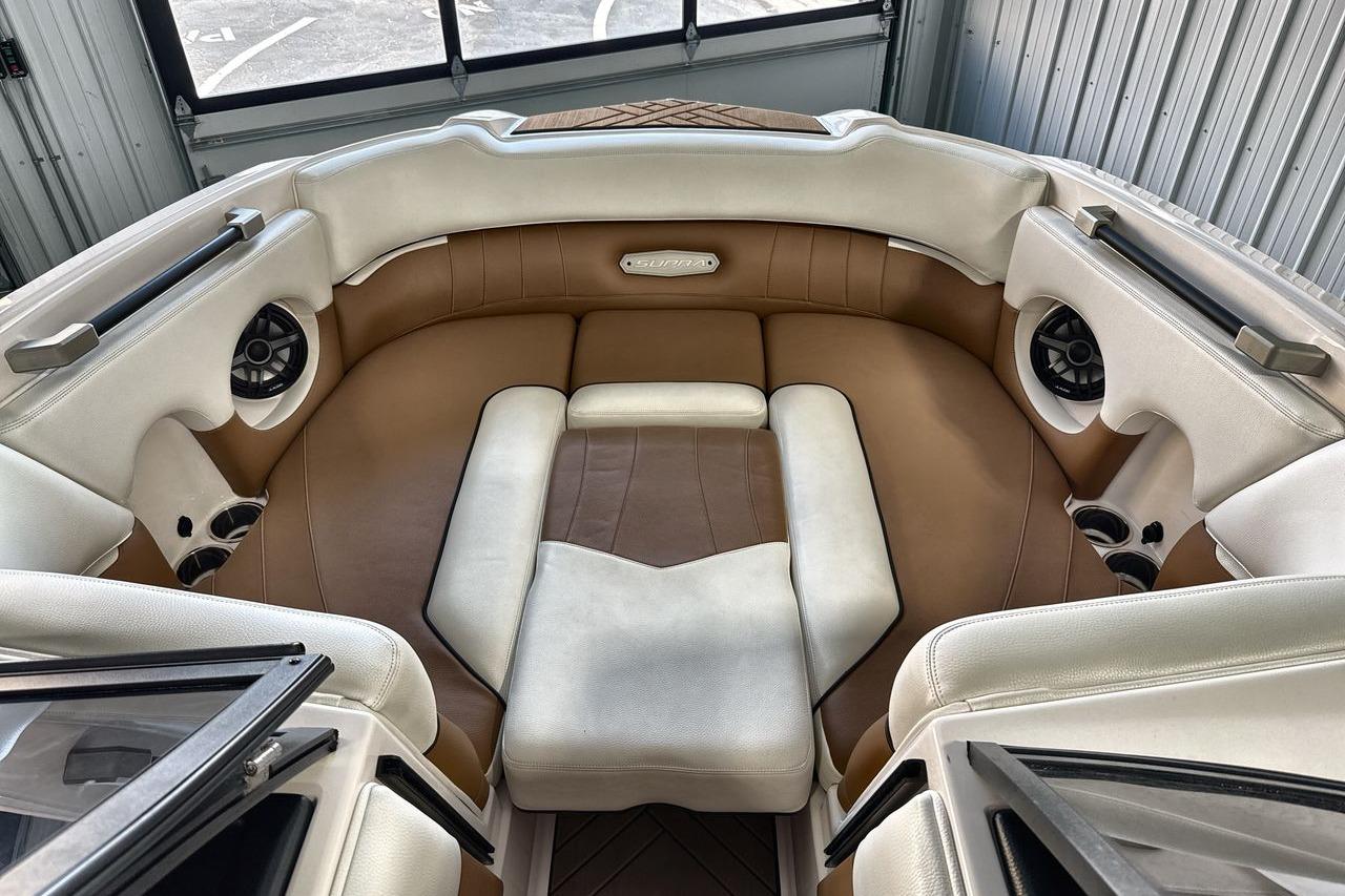 2020 Supra SE boat interior with brown and white seating, featuring built-in speakers.