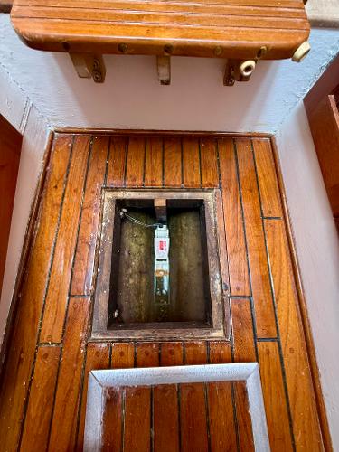 Wooden floor hatch on 1978 Dyer 29 Trunk Cabin boat, revealing interior compartment.