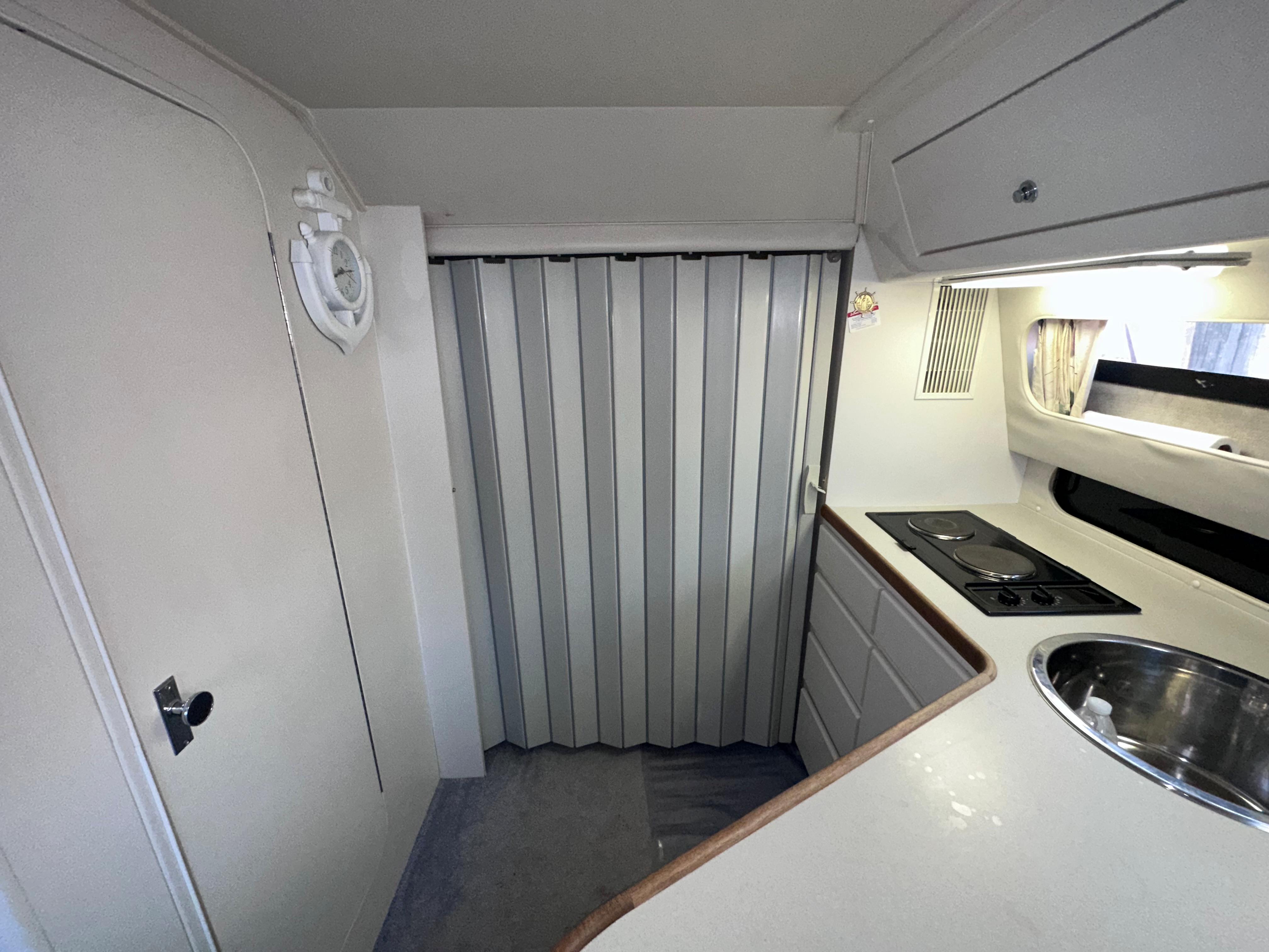 1994 Carver 340 Santego interior with compact kitchen, stove, sink, and storage cabinets.