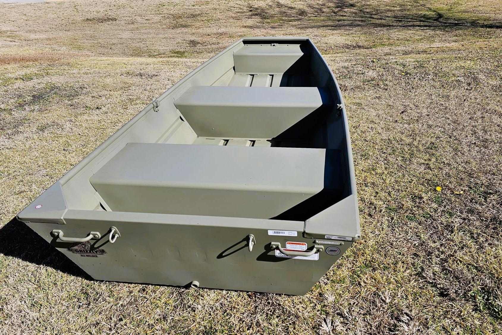 2026 Tracker Grizzly 12 Jon boat on grassy terrain, showcasing durable design and seating.