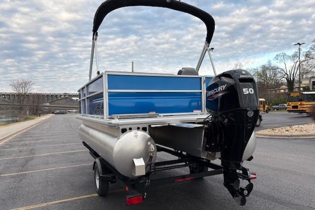 2026 Sun Tracker Party Barge 16 DLX pontoon boat with Mercury 50 engine in parking lot.