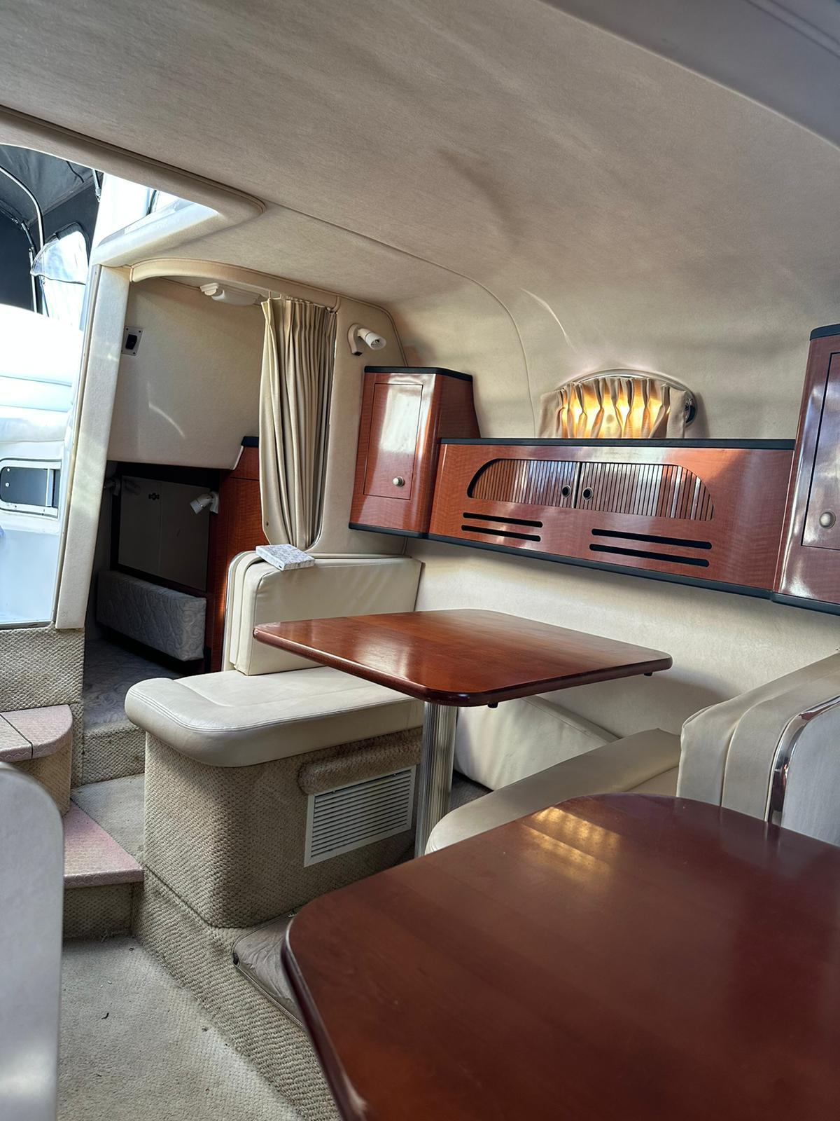 Interior of 2005 Sea Ray 280 Sundancer with wood accents and seating area.