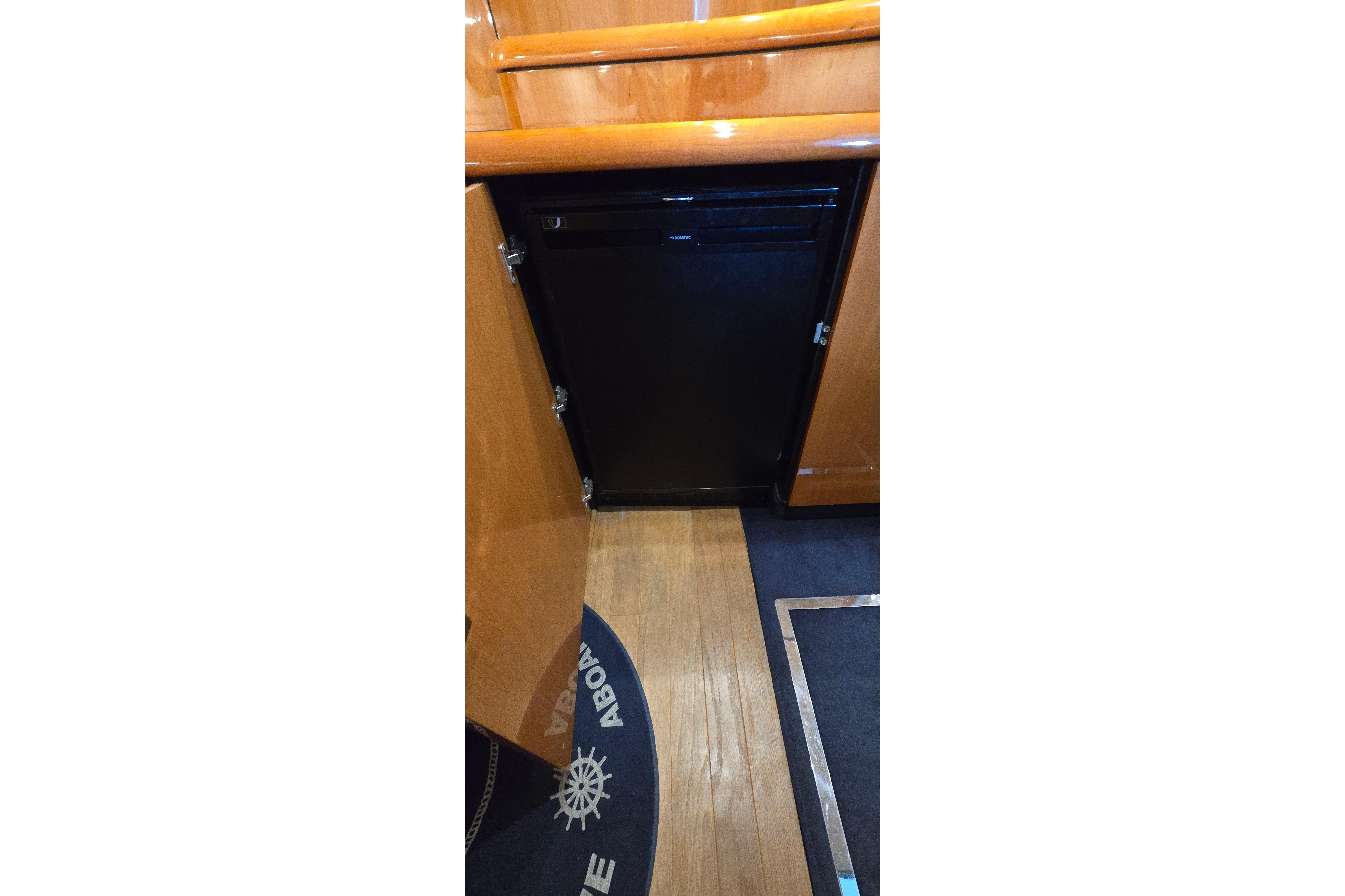Interior of 2004 Sunseeker Camargue 50 yacht, featuring wooden cabinetry and flooring.