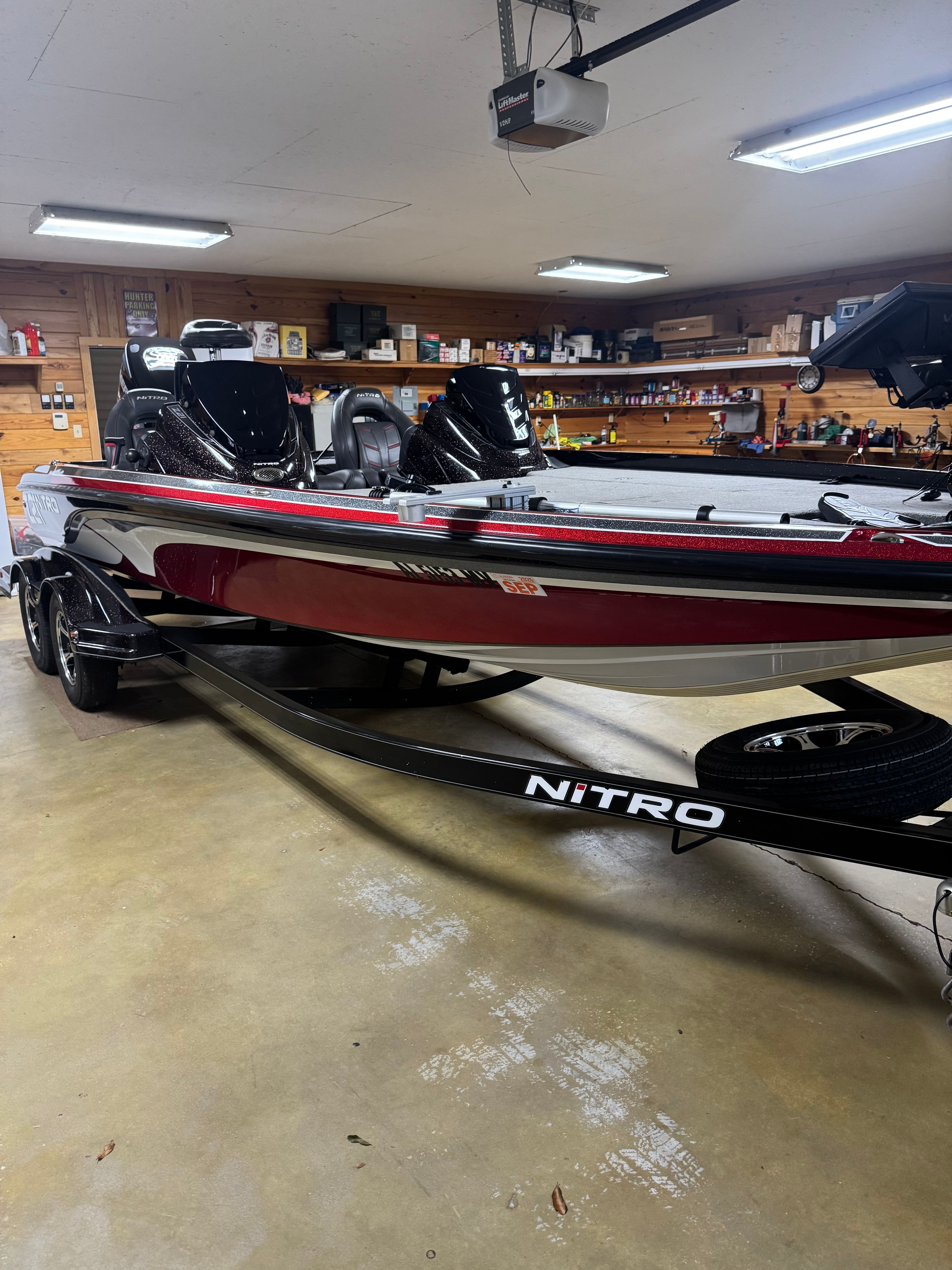 A red Nitro Z21 boat is parked in a garage.