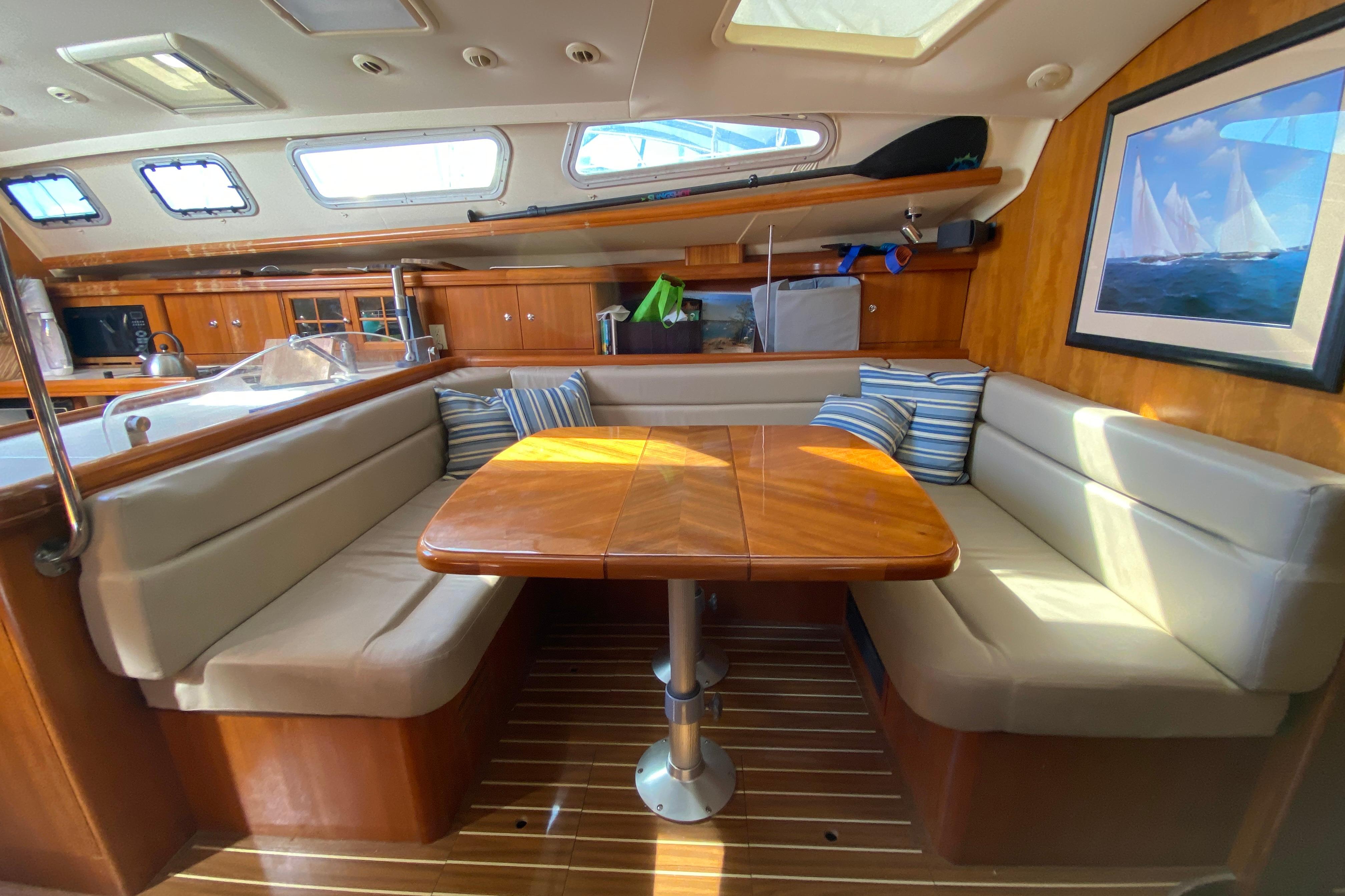 Interior of 2004 Hunter 41 AC sailboat with cozy dining area and wooden finishes.