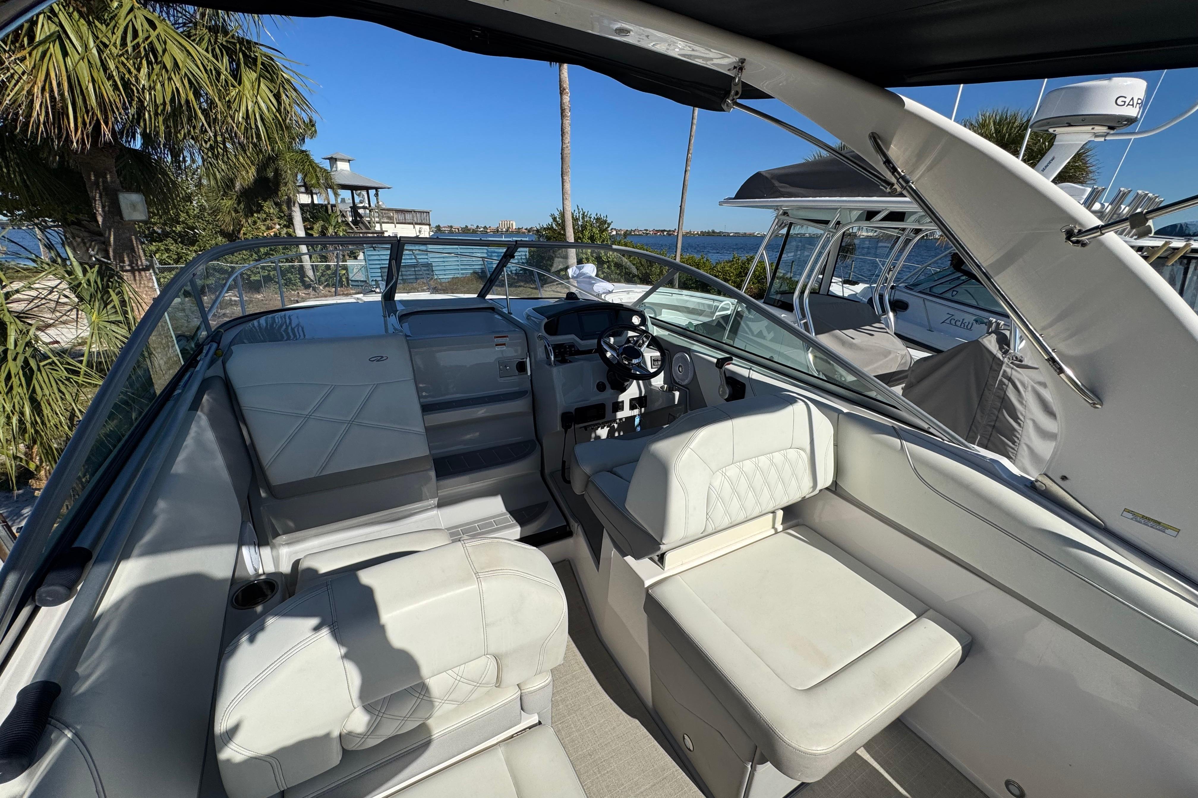 2021 Regal 26 XO boat interior with white seating and steering console, near waterfront.