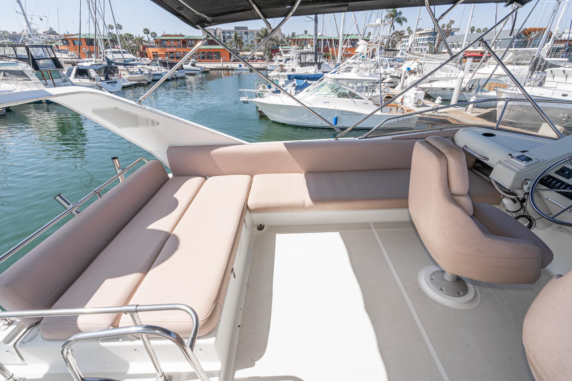 1992 Bayliner 4388 yacht interior with beige seating, docked at a marina.