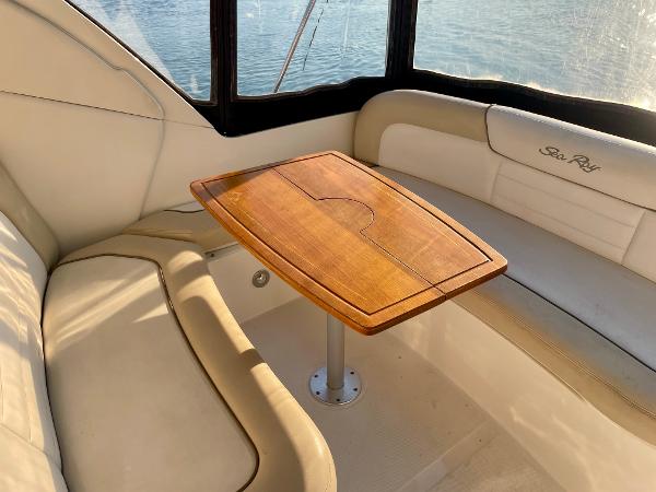 2014 Sea Ray 330 Sundancer interior with wooden table and cushioned seating.