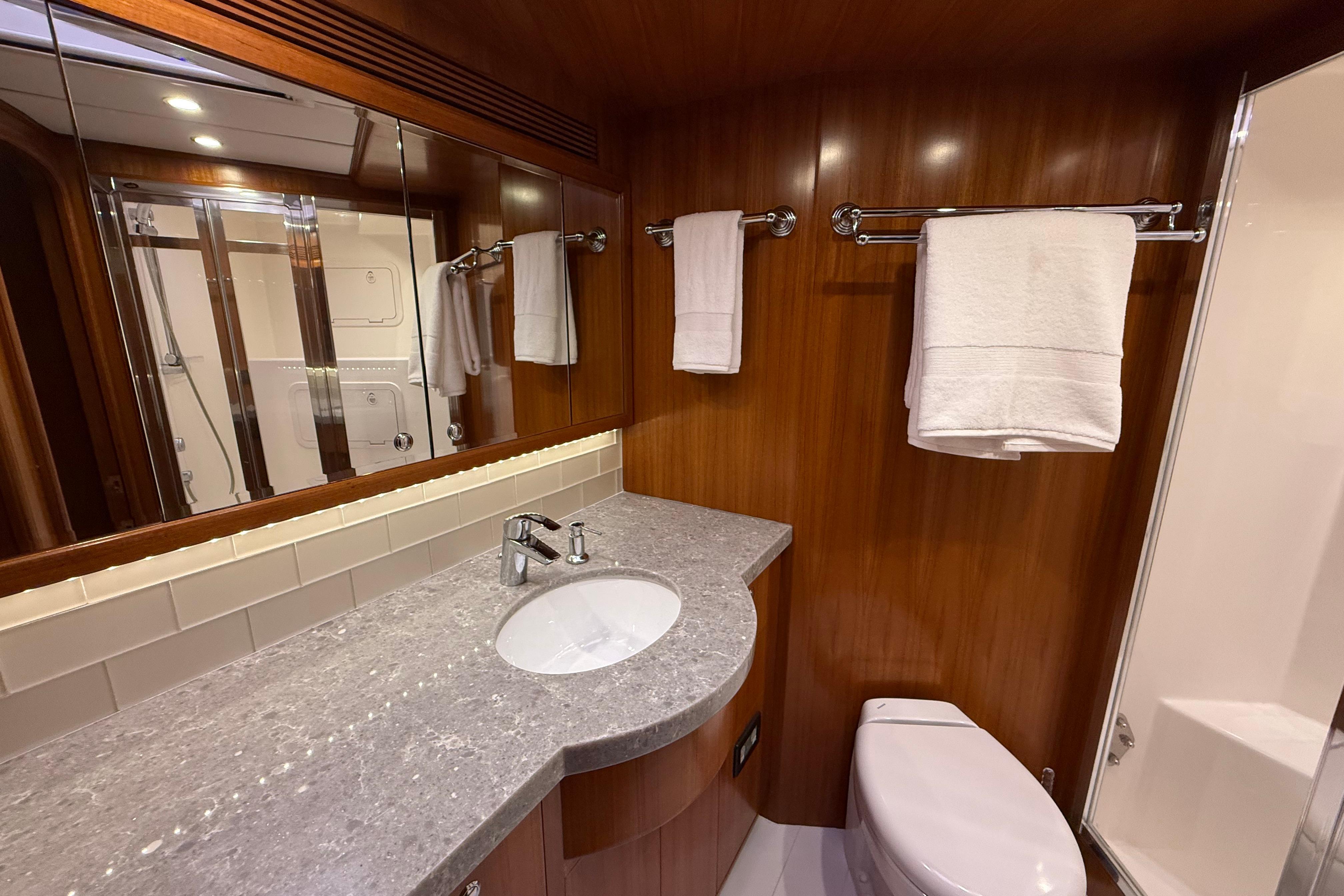 Luxurious bathroom in 2009 Nordhavn N64 yacht with wood paneling and modern fixtures.