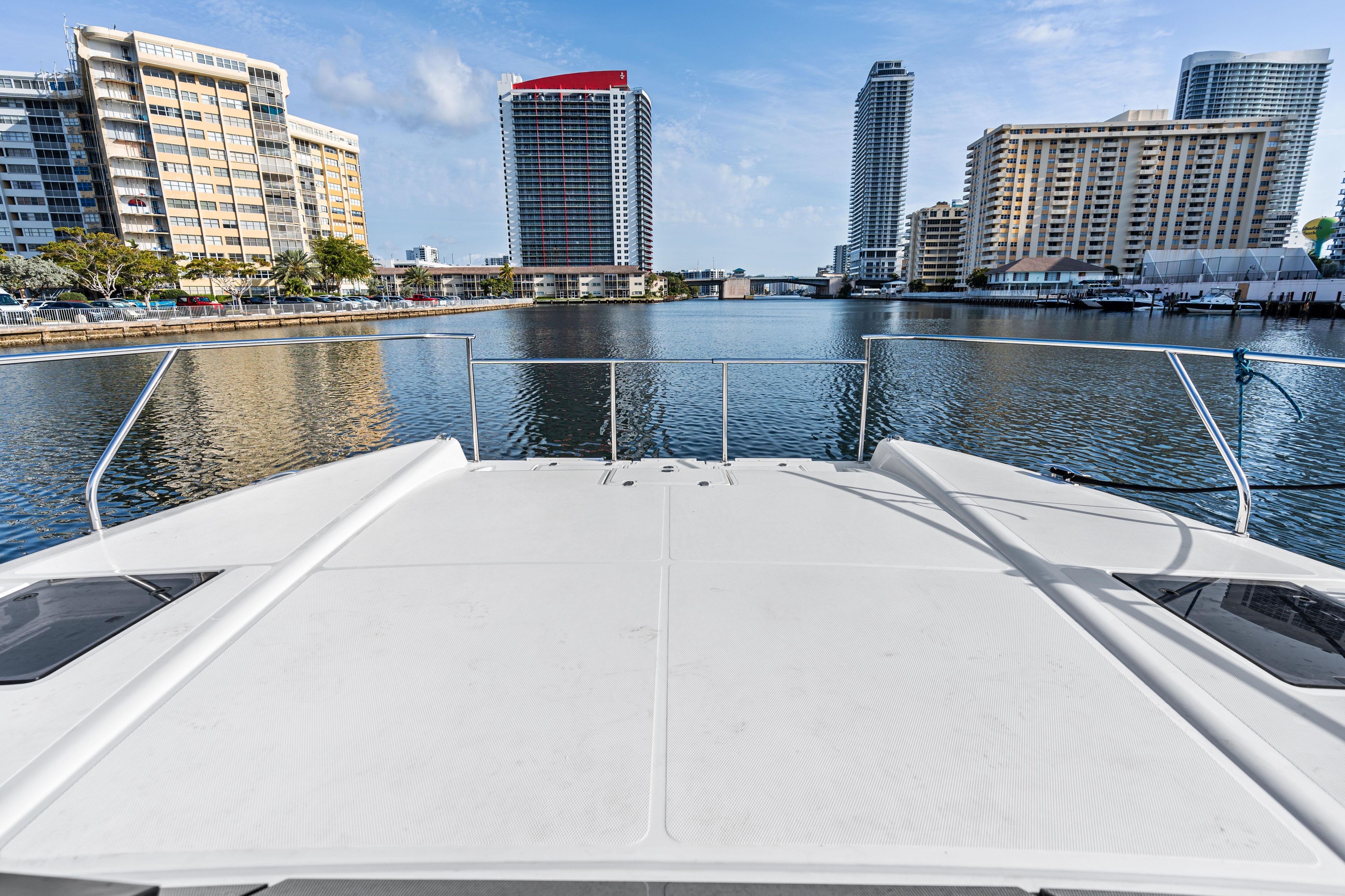 Bow view from Makai M37 yacht, 2025, overlooking urban waterfront skyline.