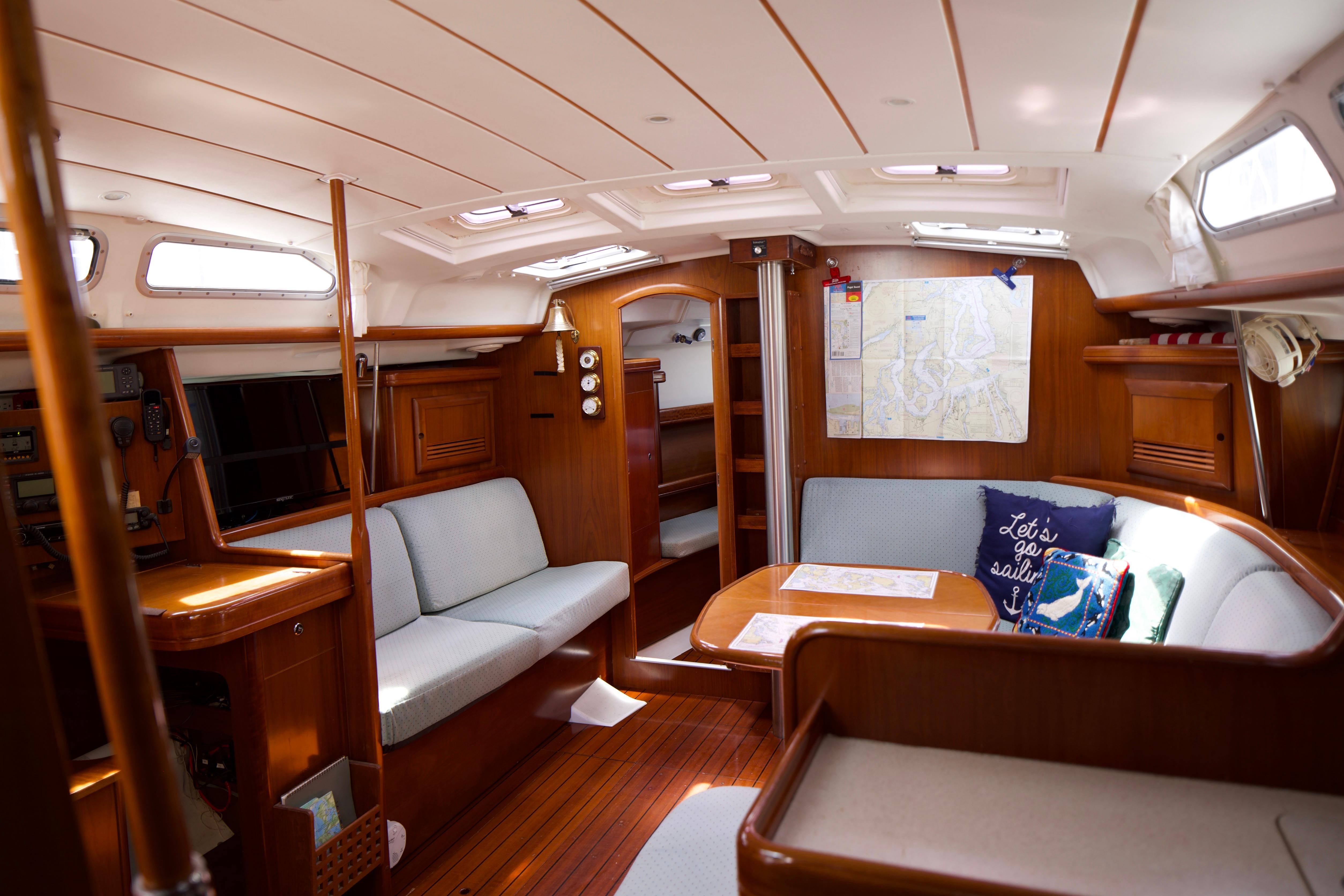 Interior of 2005 Beneteau 423 sailboat with cozy seating and nautical decor.