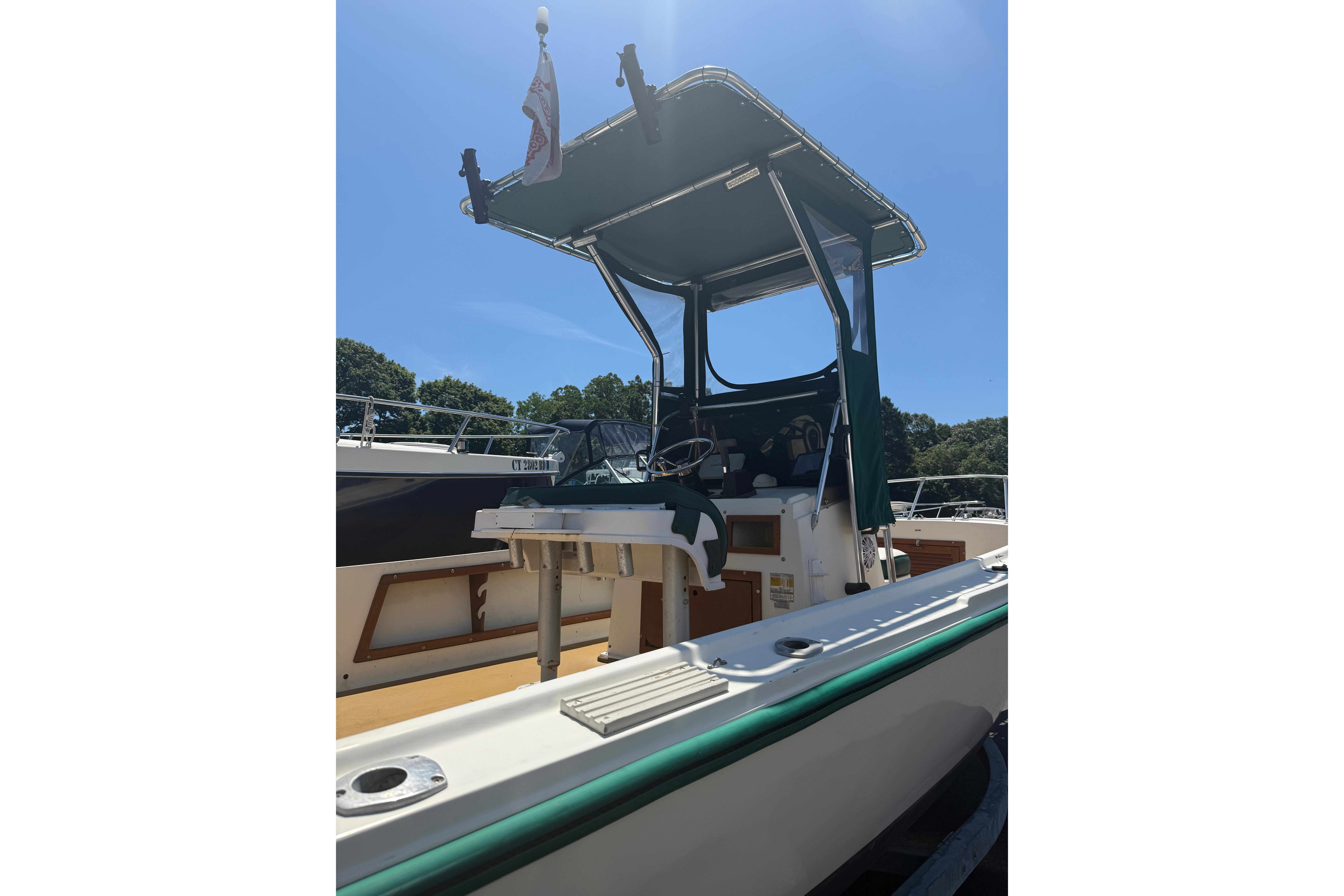 1982 Mako 20 Center Console boat with canopy, docked under clear blue sky.